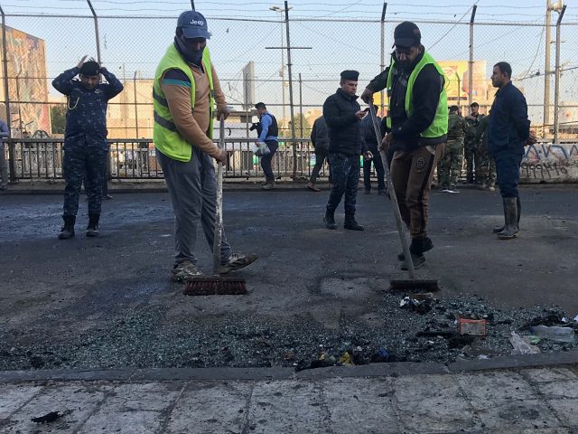 Workers clean after the attack in Baghdad