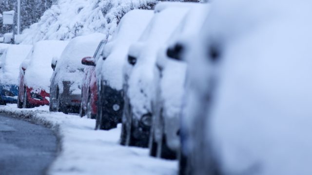 Cars covered with snow amid cold weather (David Cheskin/PA)