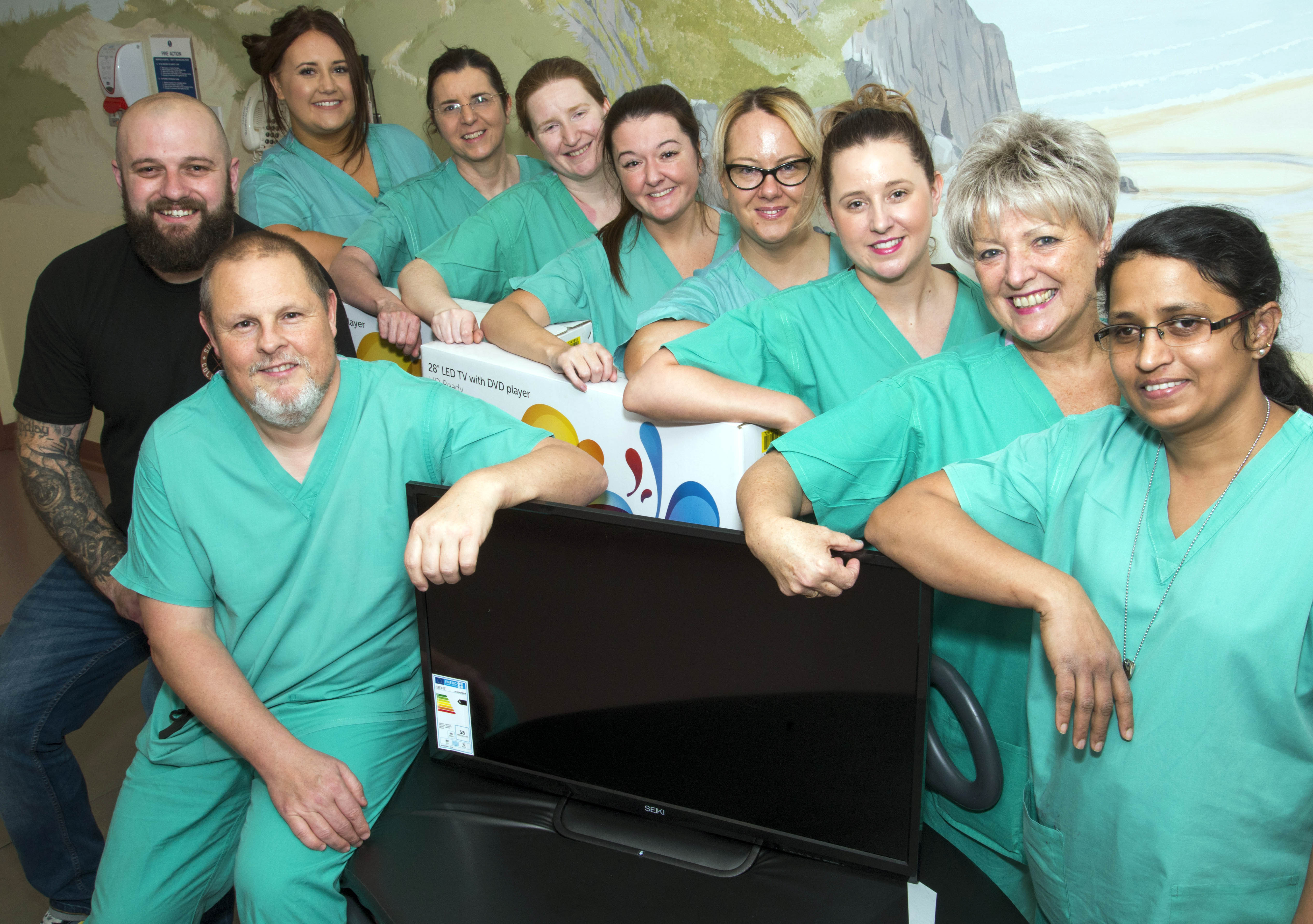 Chris Roe (far left) presents TV sets to Tempest Burns ITU Unit staff to thank them for the care they provided to his teenage son Kyle Roe (ABMU Health Board/PA).