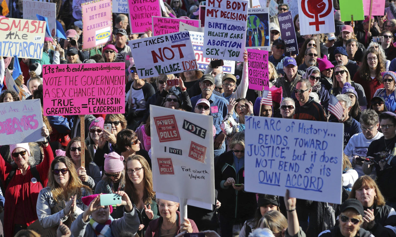 Women and men hold a variety of signs in Fort Worth, Texas (Rodger Mallison/AP)