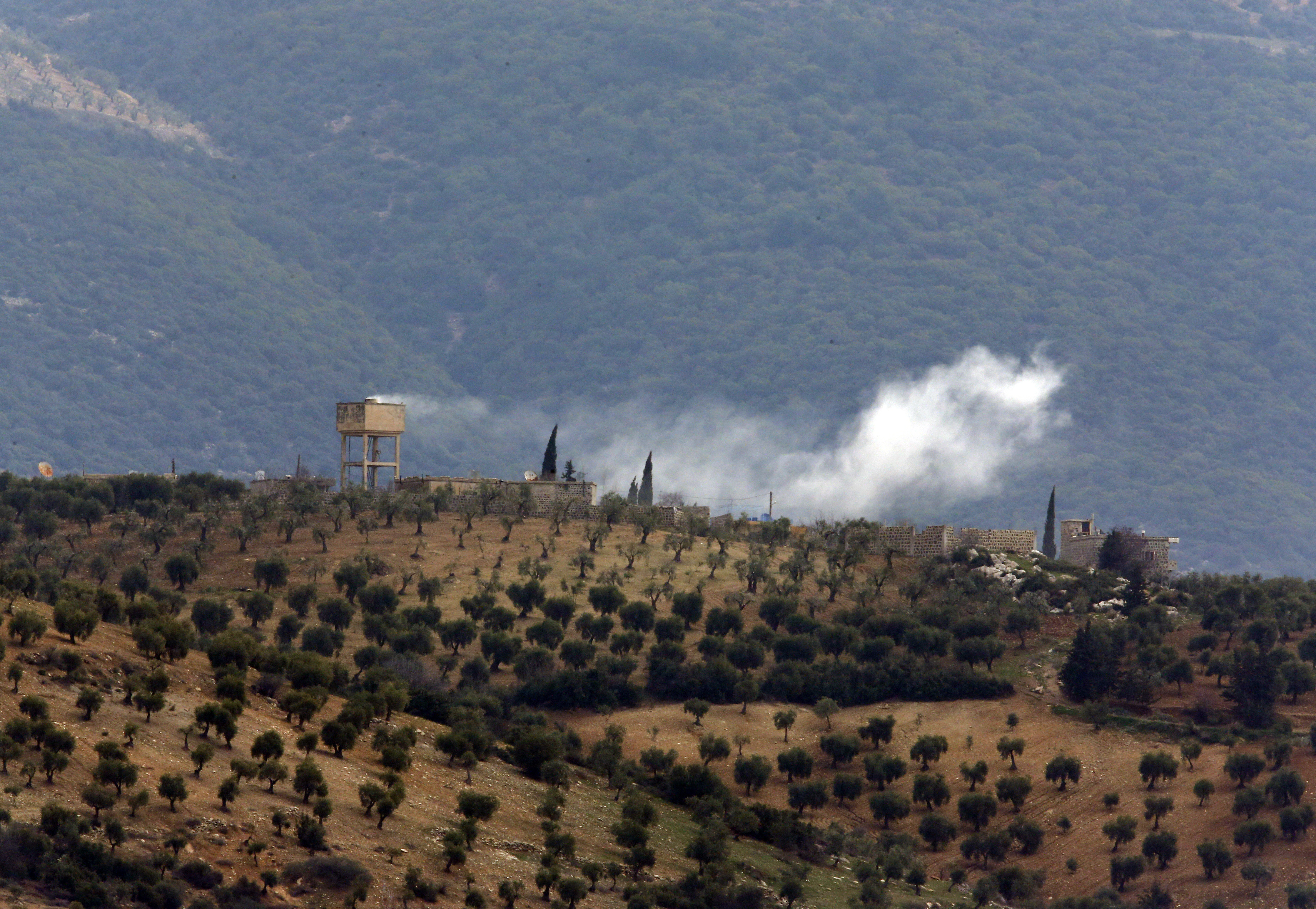 Smoke billows from a position inside Syria, after a Turkish army artillery fired (Lefteris Pitarakis/AP)