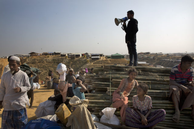 A Rohingya volunteer guides fellow refugees on their arrival at Balukhali refugee camp 31 miles from Cox's Bazar, Bangladesh (Manish Swarup/AP/PA)