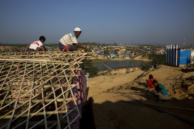 A Rohingya father and son make their temporary shelter at Kutupalong refugee centre, near Cox's Bazar, Bangladesh (Manish Swarup/AP/PA)