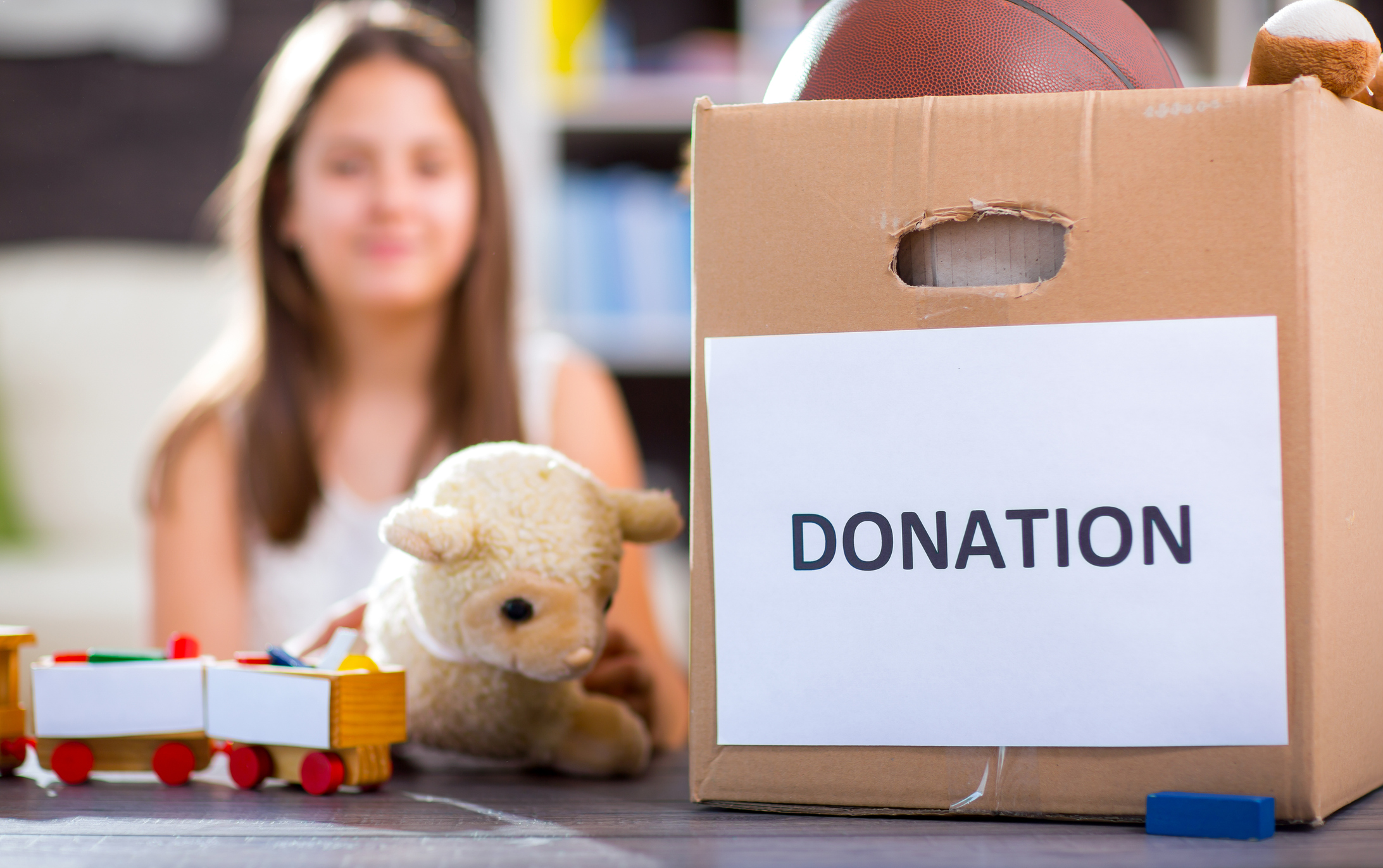 Girl taking donation box full with stuff for donate