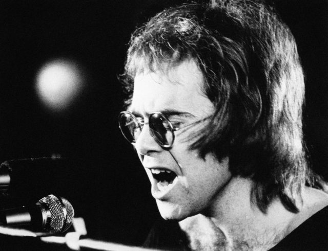 Elton John sings in to the microphone on stage during a gig in 1971 (PA)
