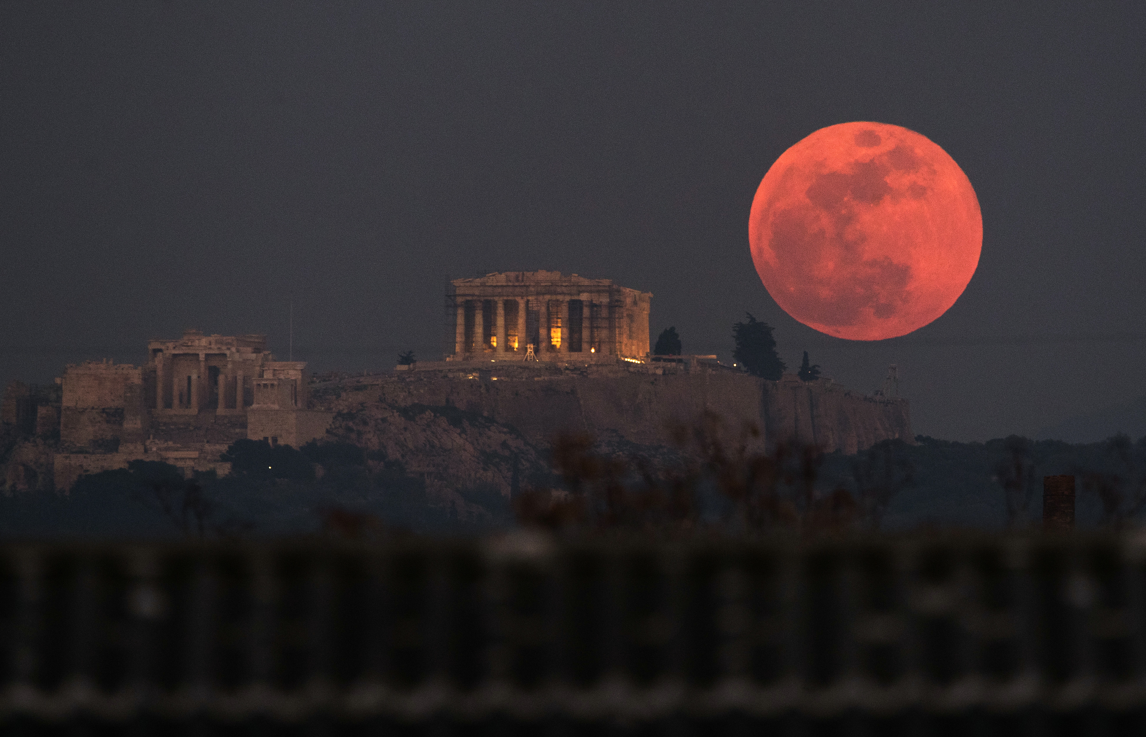 A super blue blood moon rises behind the Parthenon temple on the Acropolis of Athens, Greece (Petros Giannakouris/PA)