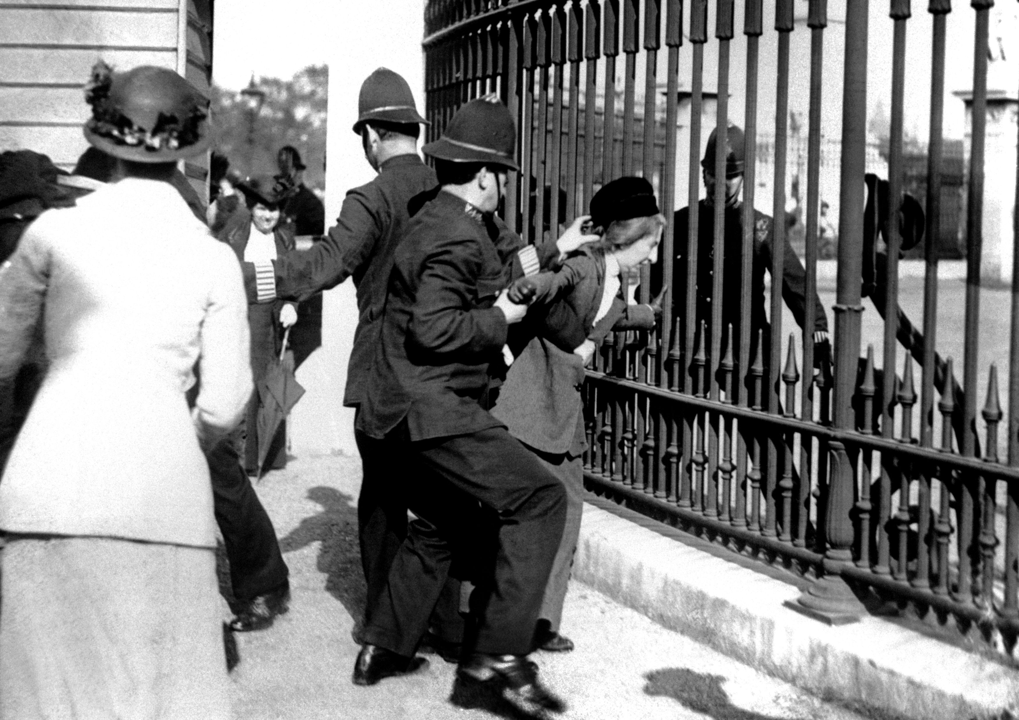 A policeman restraining a demonstrator in 1914 as suffragettes gathered outside Buckingham Palace (PA)