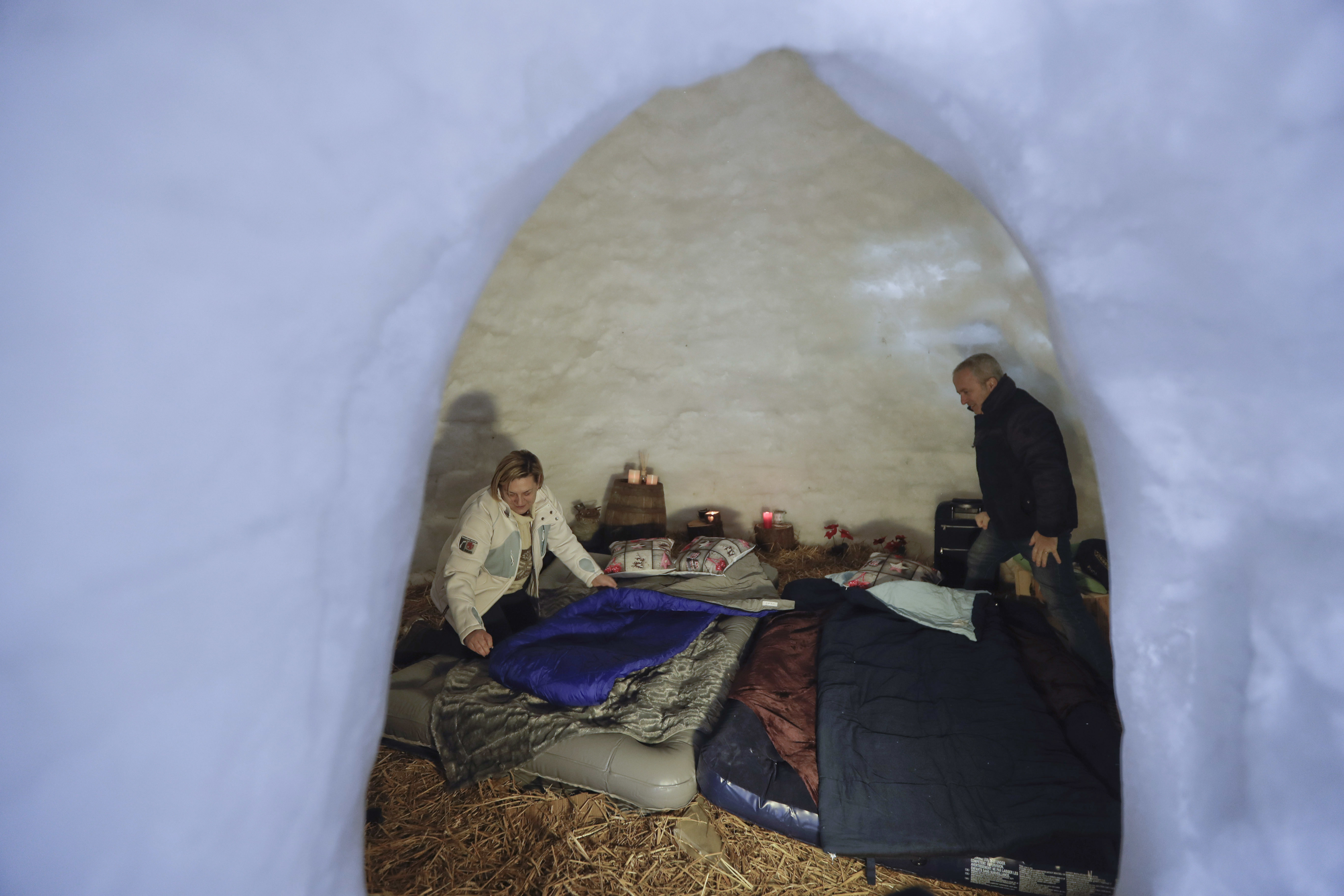 Tourists Elena Rota and Giovanni di Giovanni prepare beds for the night inside an igloo in San Simone (Luca Bruno/AP)