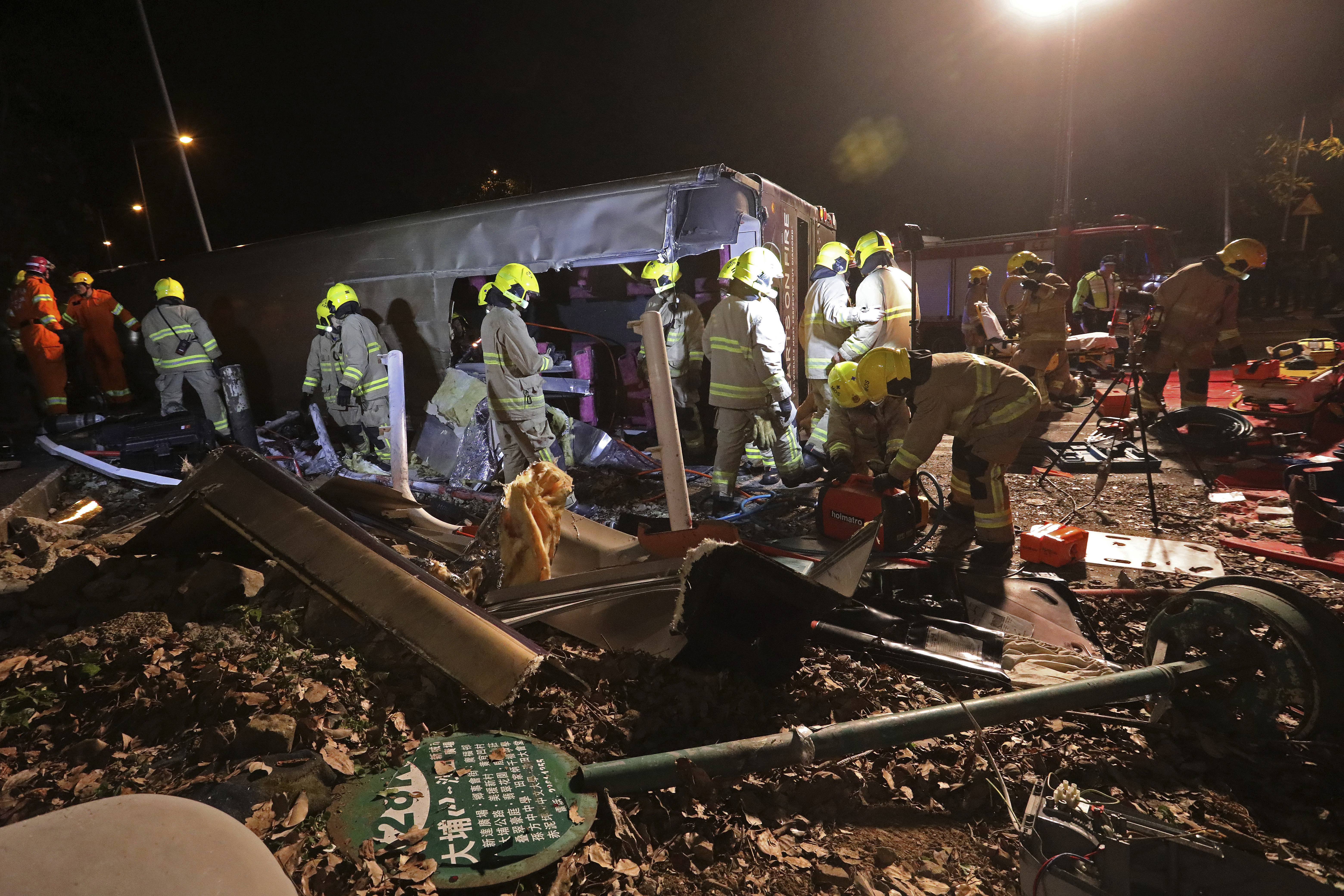 Firemen work at the scene of a bus crash in Hong Kong (Apple Daily via AP)