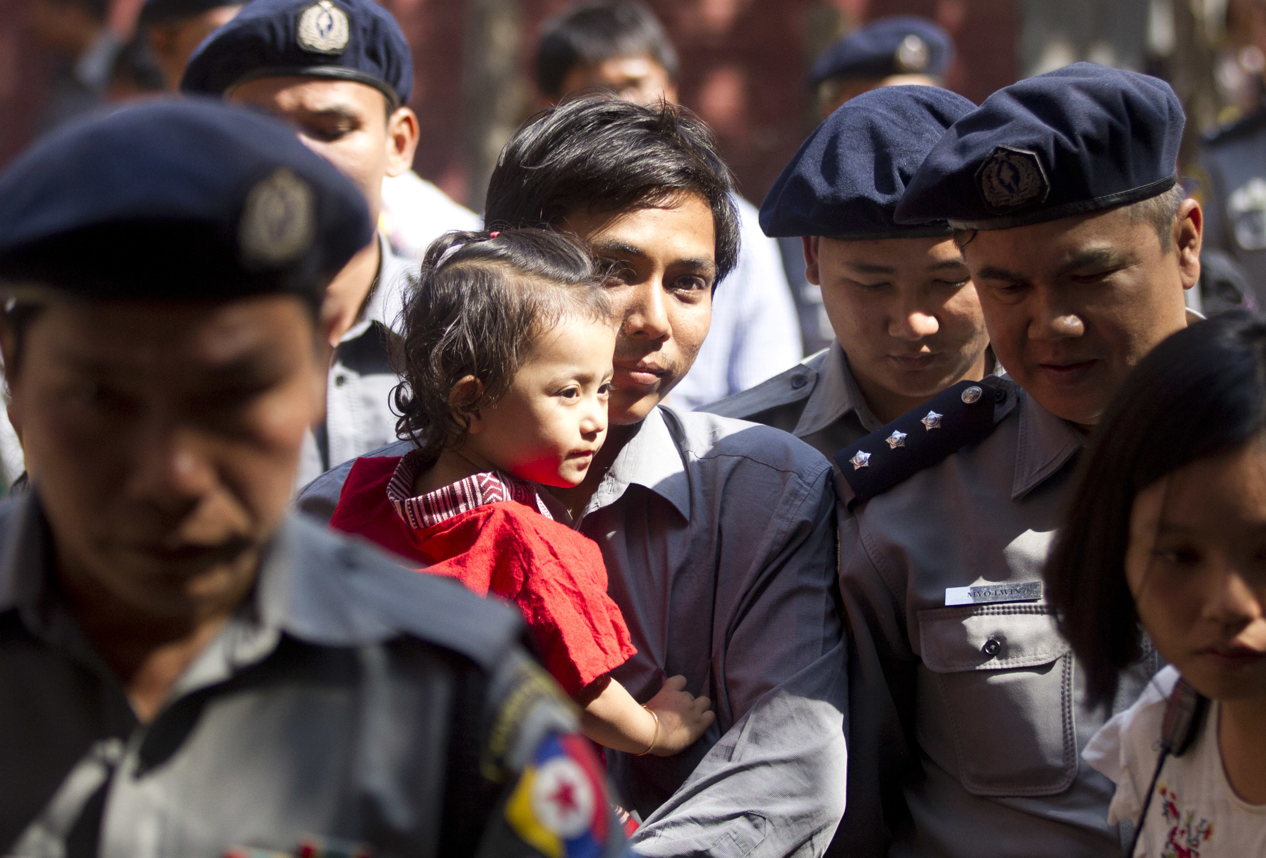 Kyaw Soe Oo carrying his daughter at a previous hearing (Thein Zaw/AP)