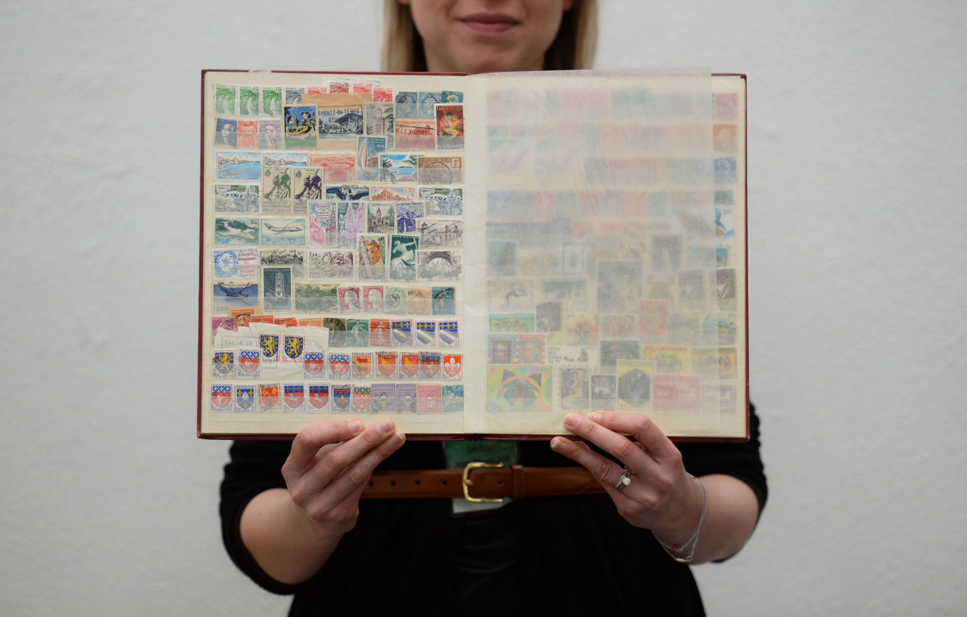 A visitor holds a stamp album from the collection (Kirsty O'Connor/PA)