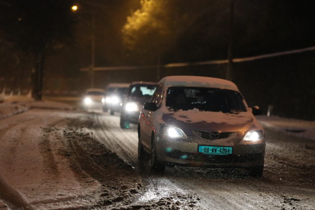 Cars pass along the Finglas Road in Dublin as heavy snow has caused more misery for travellers overnight. (Brian Lawless/PA)