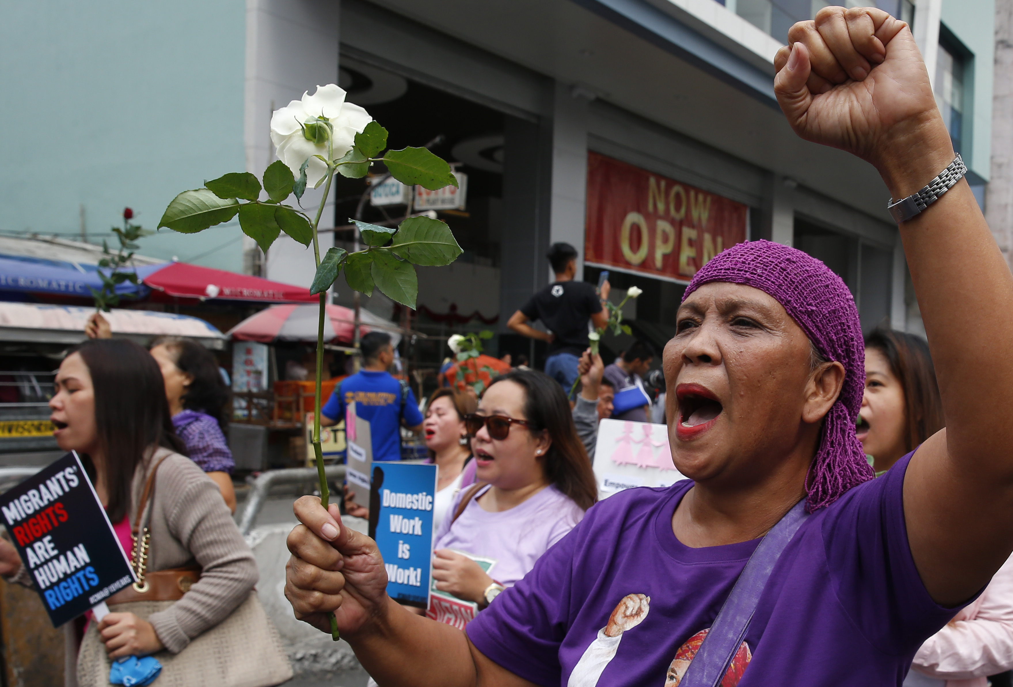 Protesters shout slogans as they march towards a Manila square for a rally to mark International Women's Day