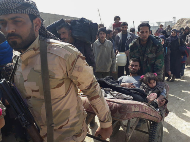 Syrian government forces soldiers helping civilians who fled from fighting between the Syrian government forces and insurgents, near Hamouria in eastern Ghouta (SANA via AP)