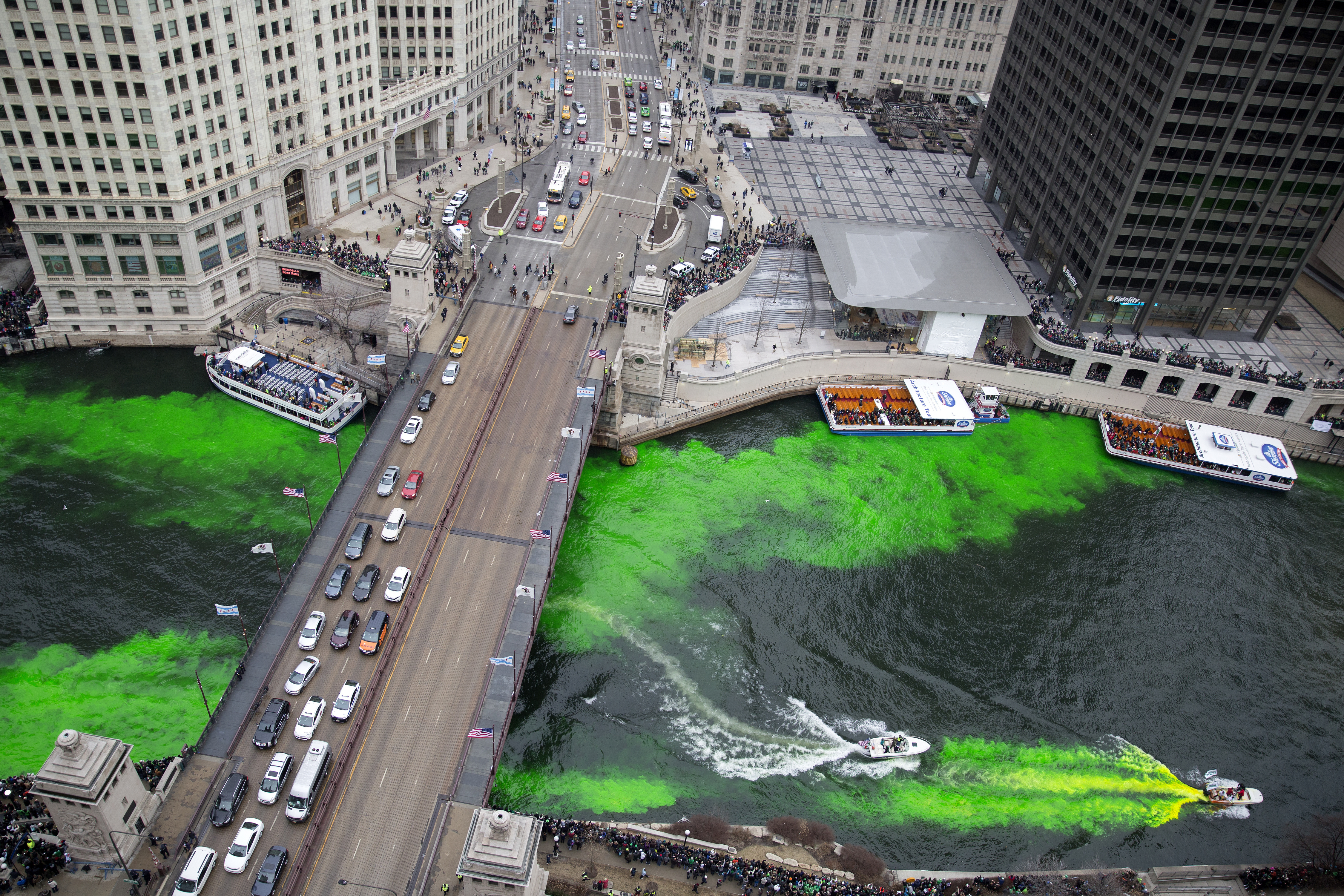 Boats move through the water as the Chicago River is dyed green for St Patrick's Day 