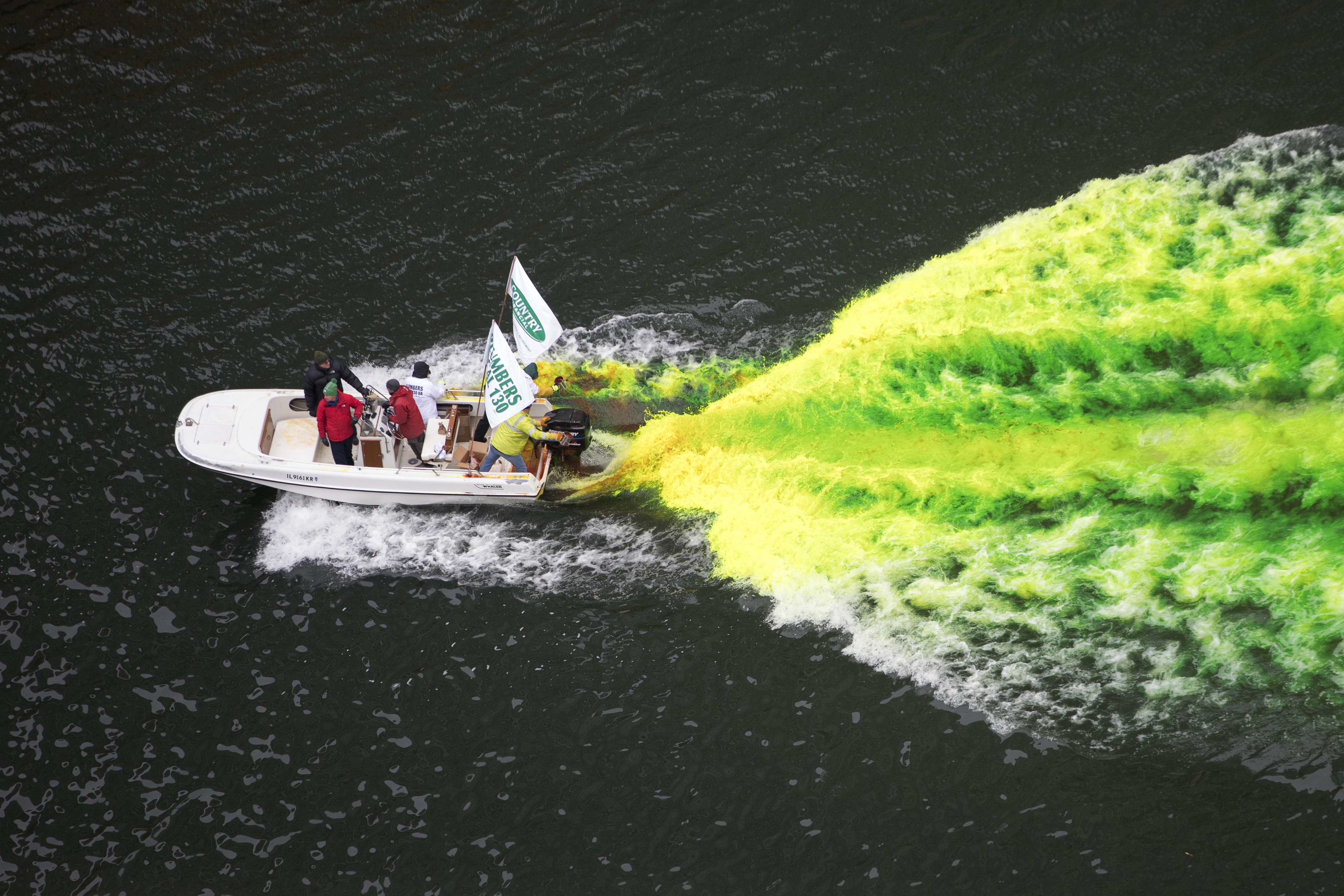 A boat move through the water as the Chicago River is dyed green for St Patrick's Day