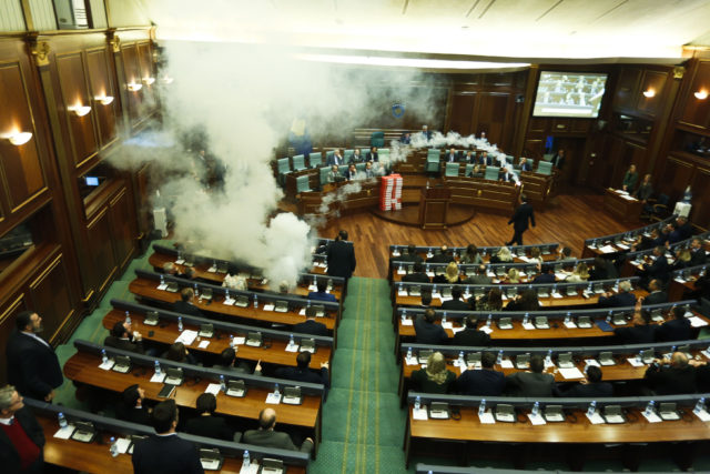 Opposition politicians throw a tear gas canister disrupting a parliamentary session in Kosovo (Visar Kryeziu/AP)