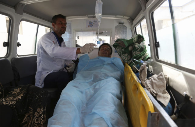 An injured man rides in an ambulance after the deadly suicide bombing near Kabul University (Rahmat Gul/AP)