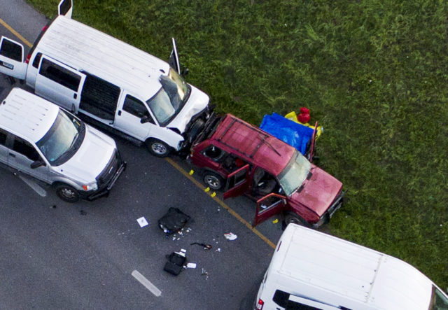 Officials investigate near a vehicle where the suspect blew himself up (Jay Janner/Austin American-Statesman via AP)