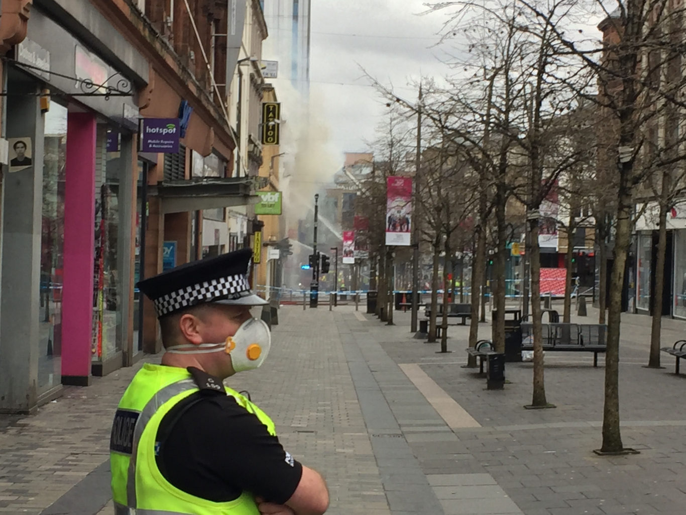 A police officer wears a face mask at the scene of the fire (Graeme Murray/PA)