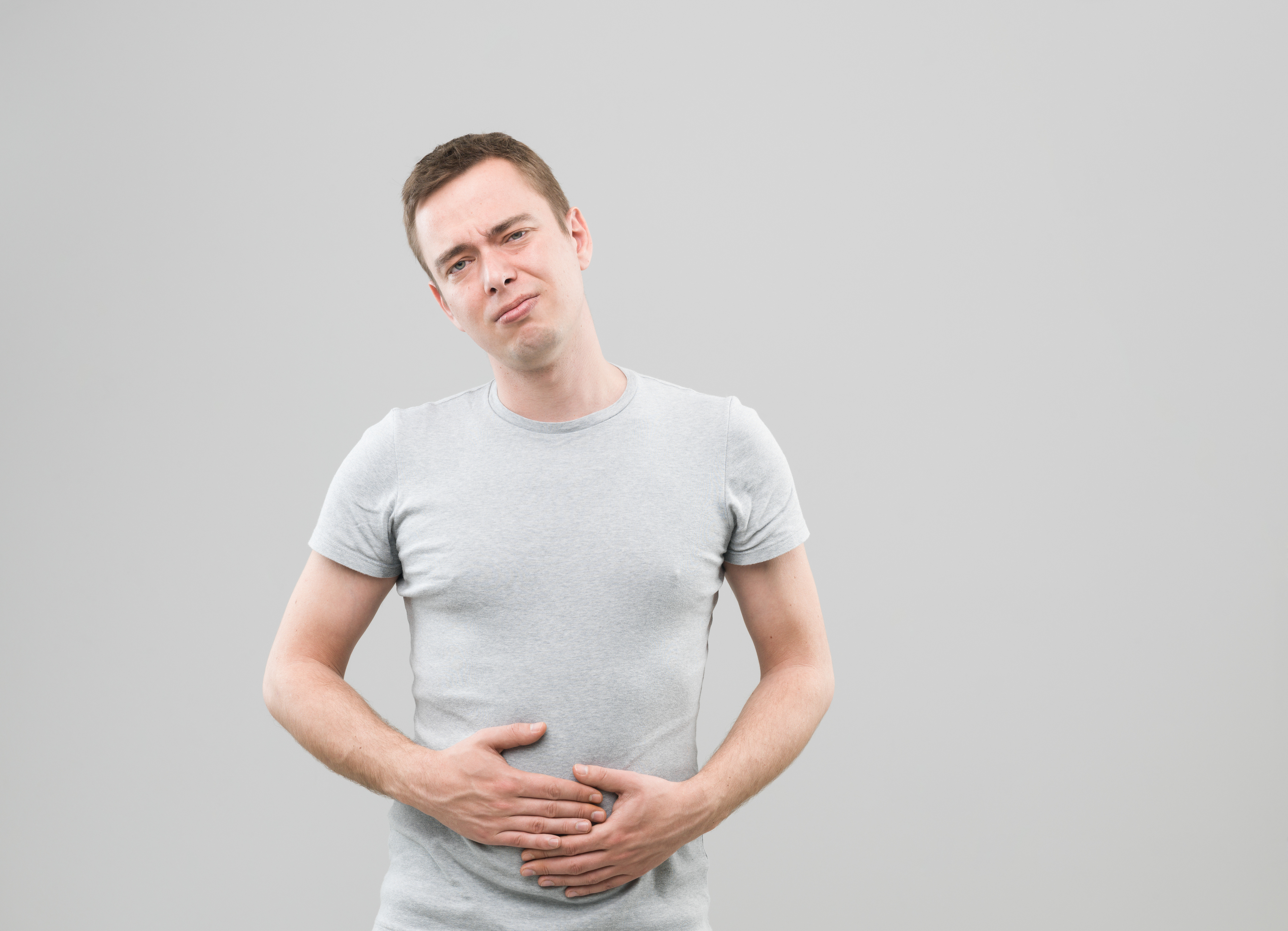 front view of young caucasian man with upset stomach