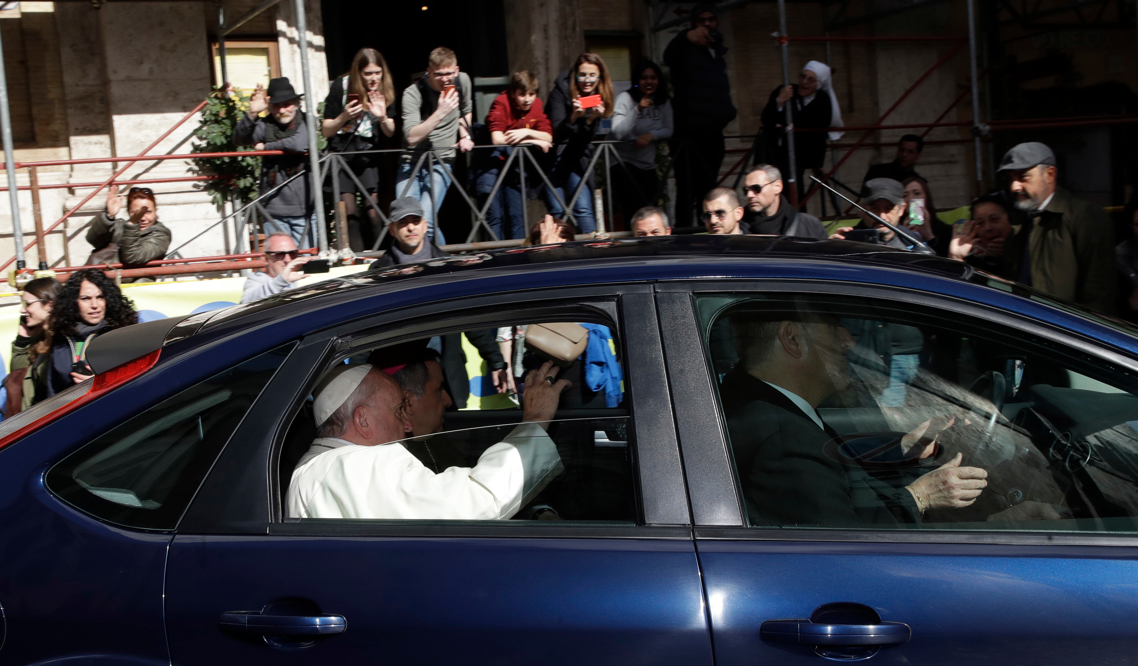Pope Francis waves on his way to Regina Coeli jail in Rome (Alessandra Tarantino/AP)