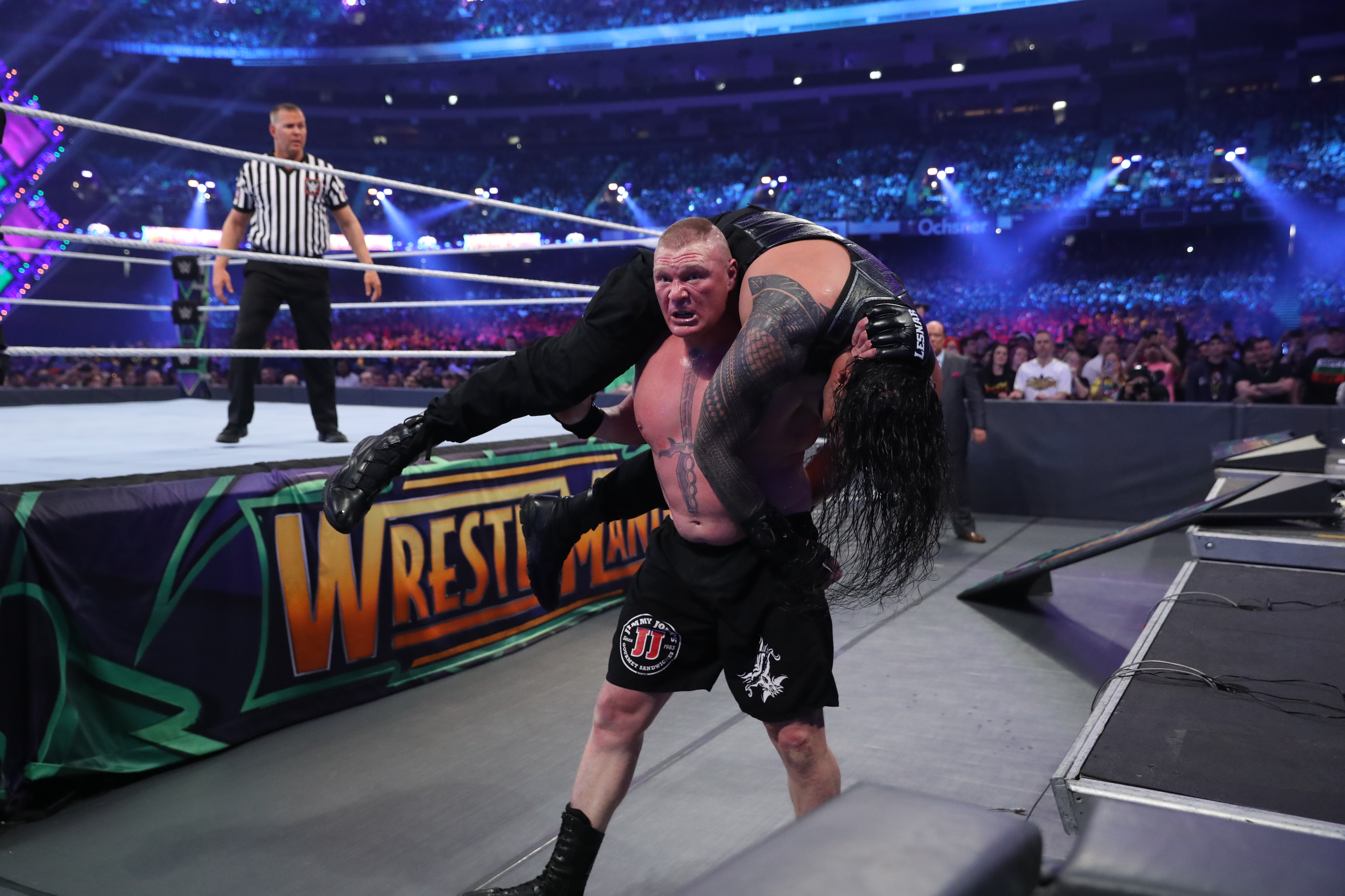 Lesnar with Reigns on his back