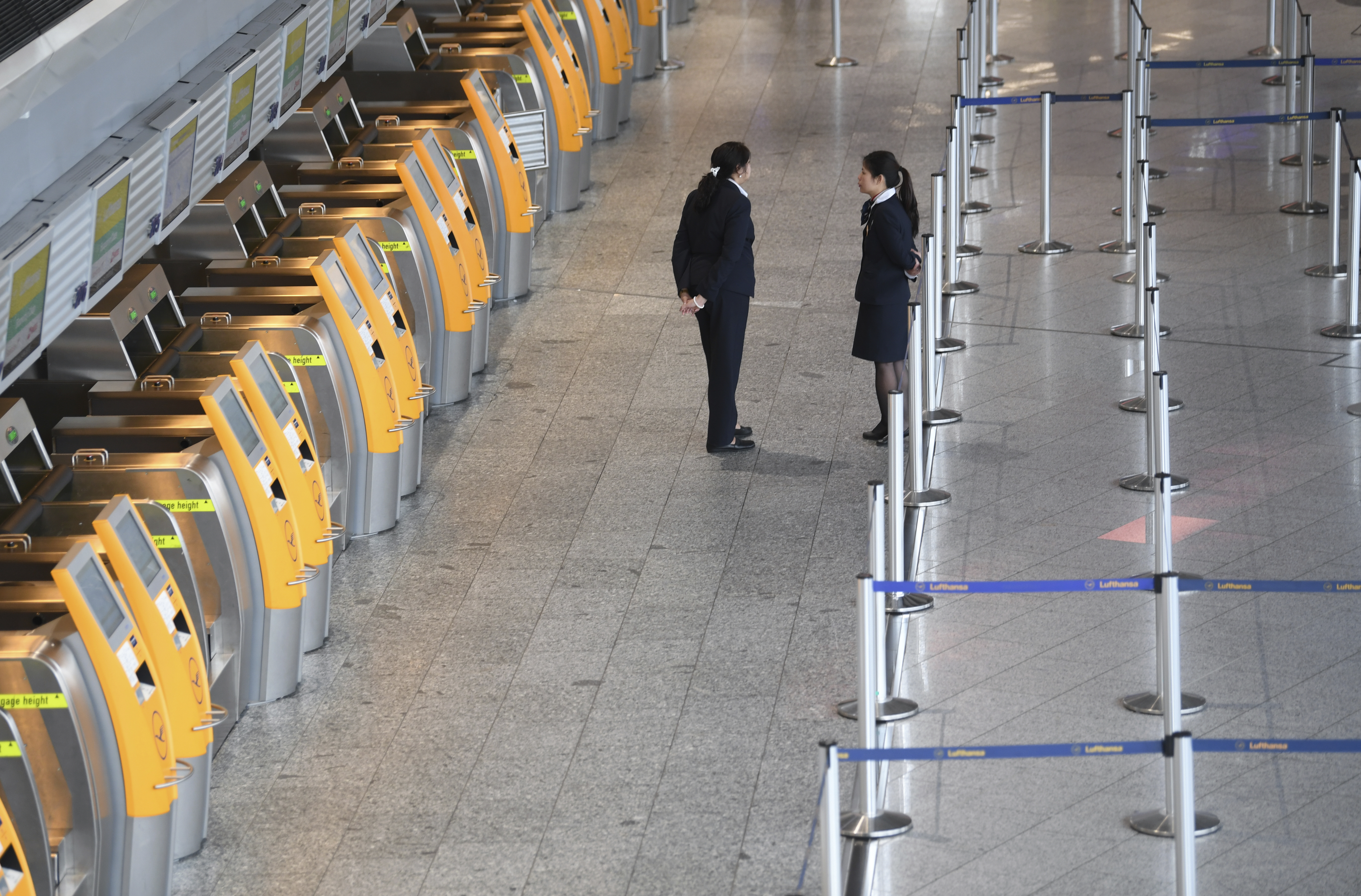 Employees at the empty Lufthansa counter in Frankfurt (Arne Dedert/dpa via AP)