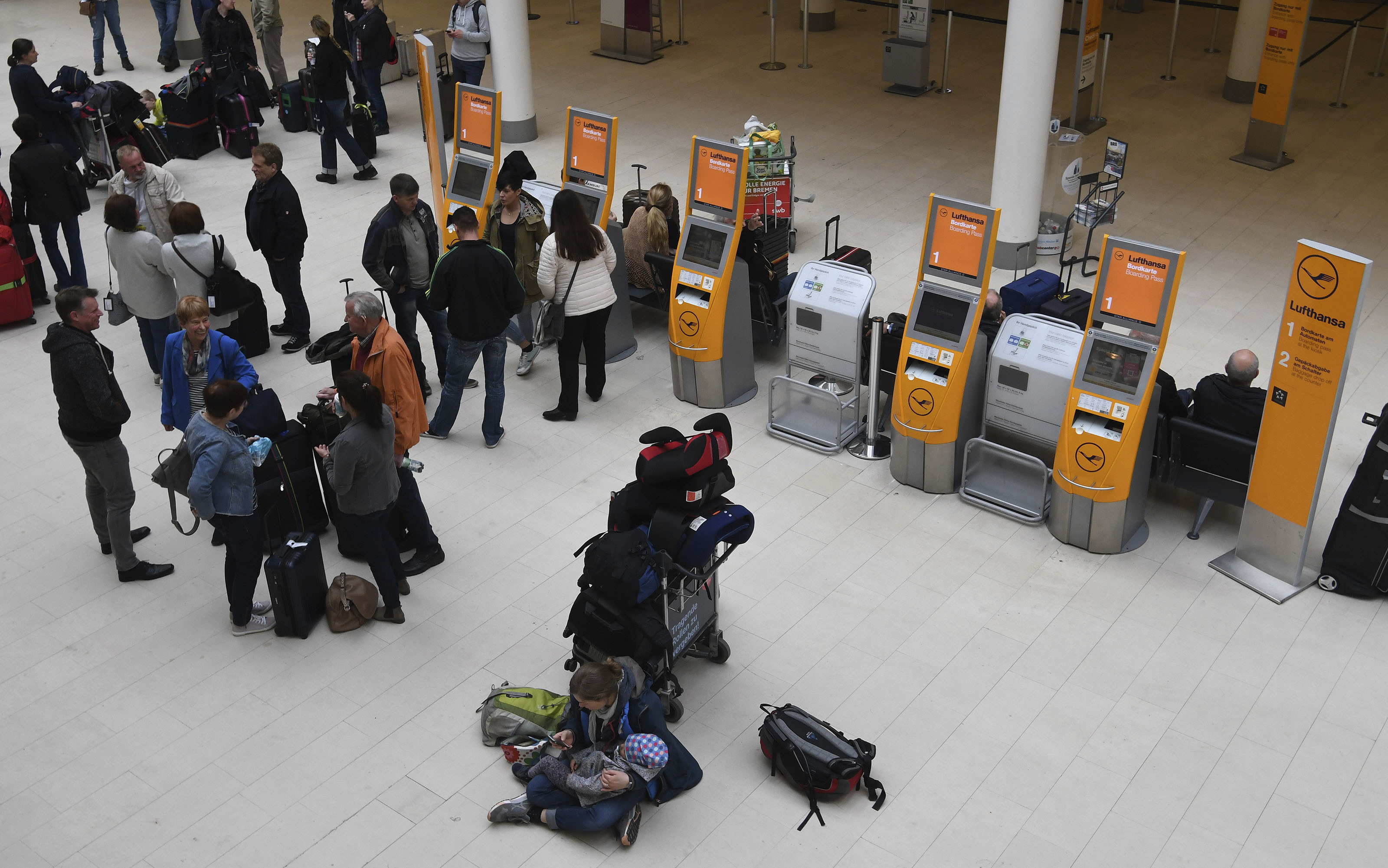 Passengers wait for the opening of the Lufthansa counter at Bremen airport (Carmen Jaspersen/dpa via AP)