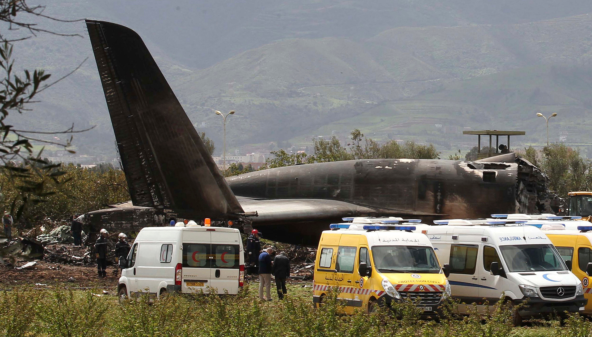 Firefighters and civil security officers at the scene (Anis Belghoul/AP)