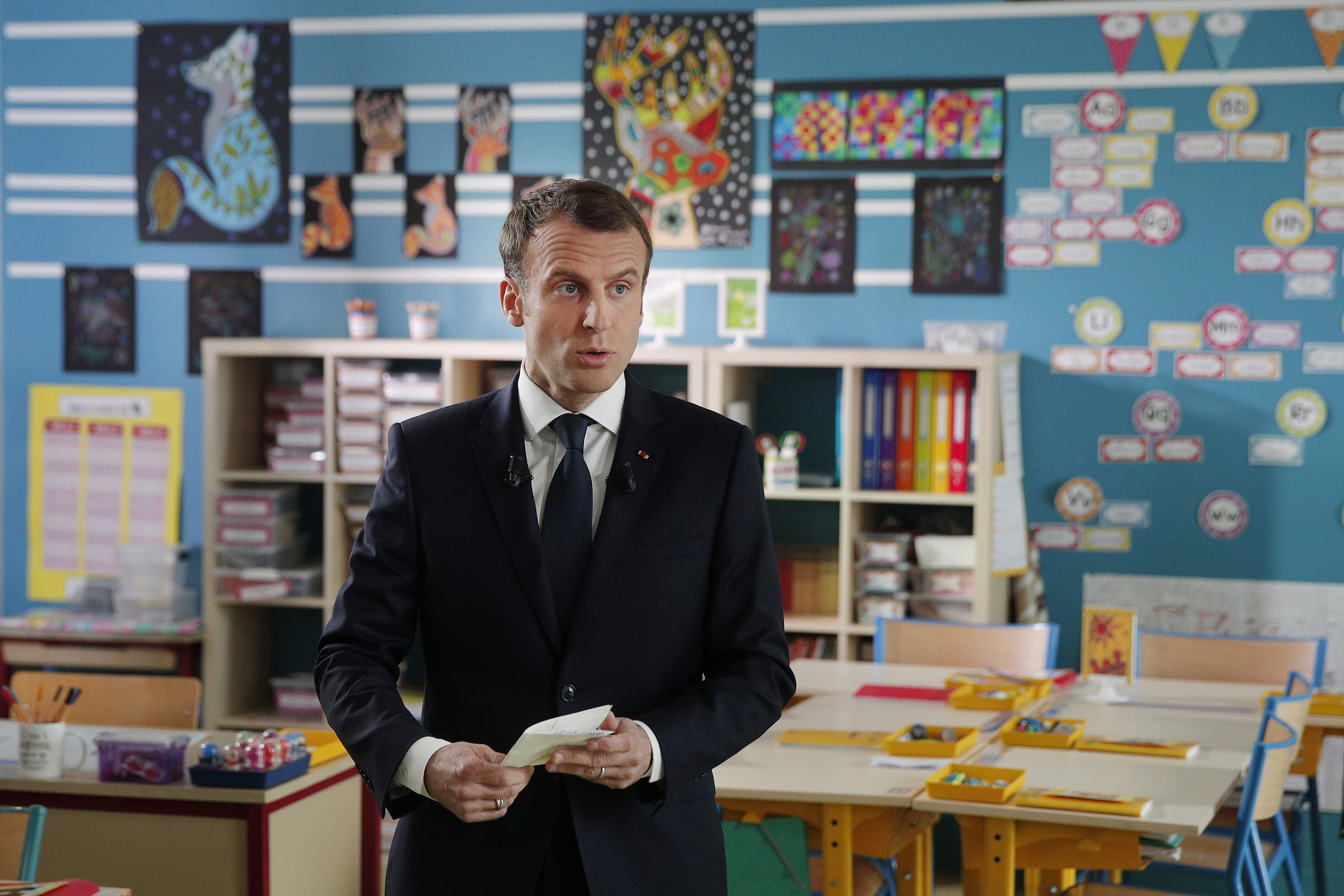 Emmanuel Macron in a classroom before a televised interview in Berd'huis, south of Paris (Yoan Valat, Pool via AP)