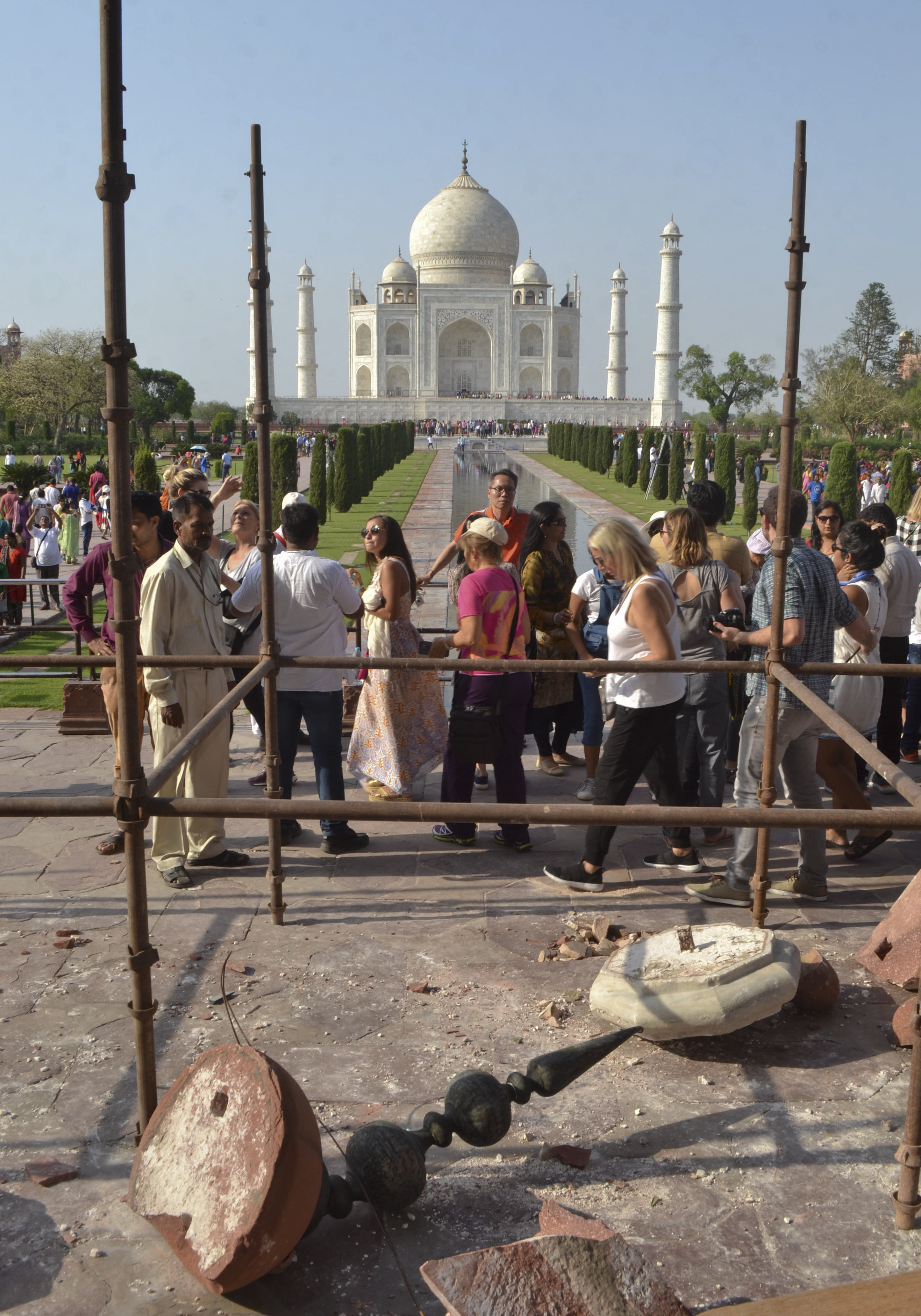 Tourists walk past the debris (Pawan Sharma/AP)