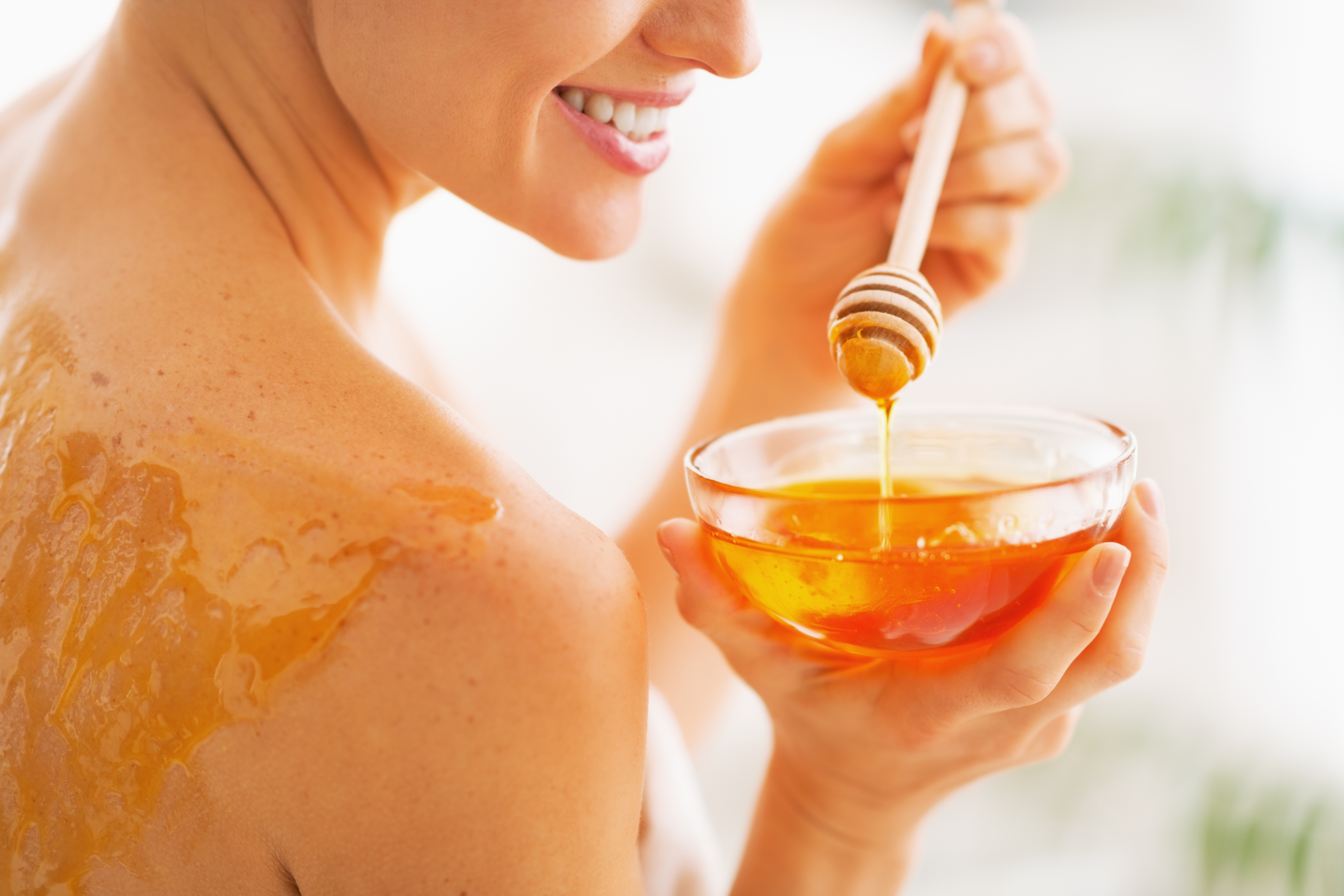 A woman putting honey on herself