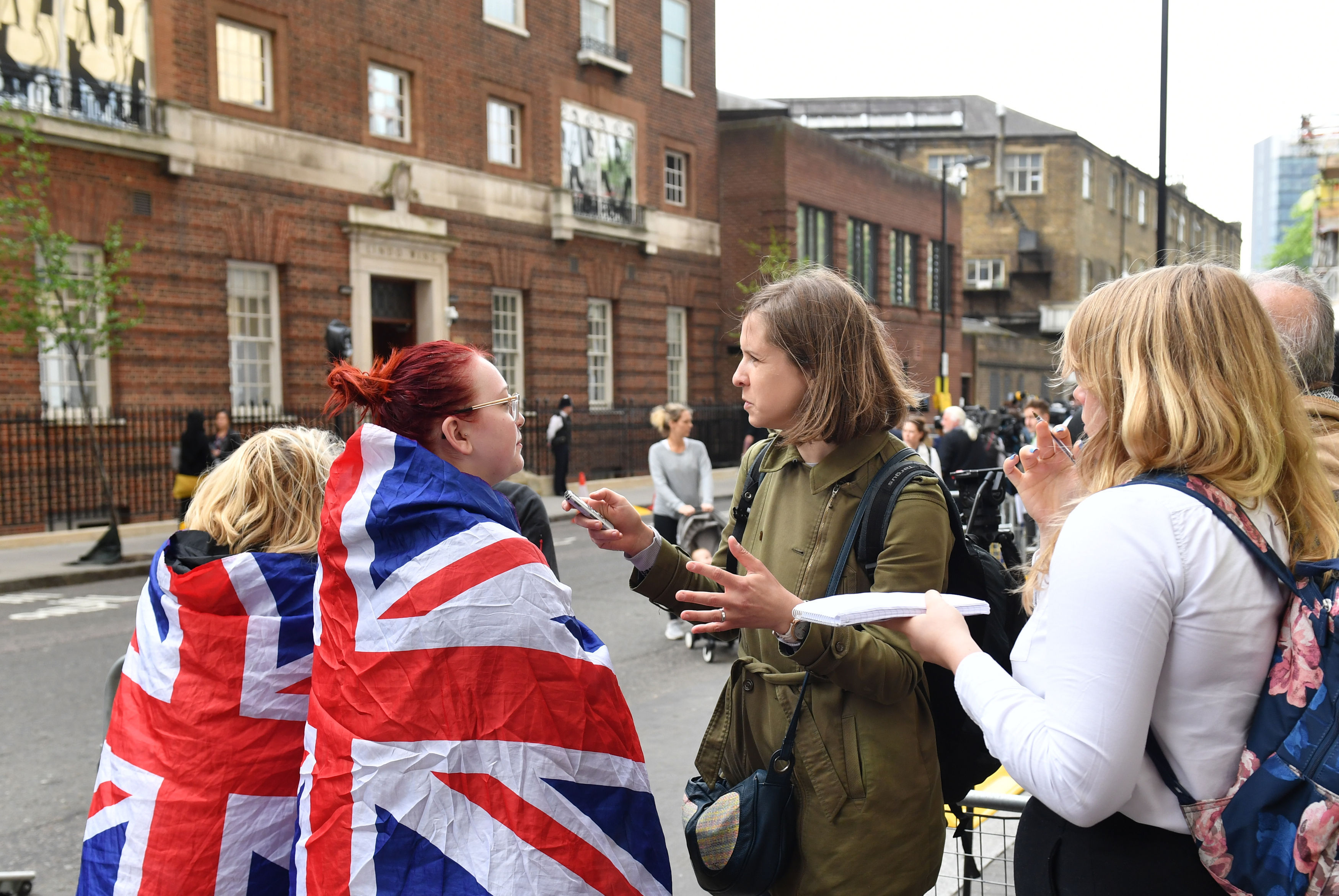 Royal fans are interviewed by journalists outside the Lindo Wing (Dominic Lipinski/PA)