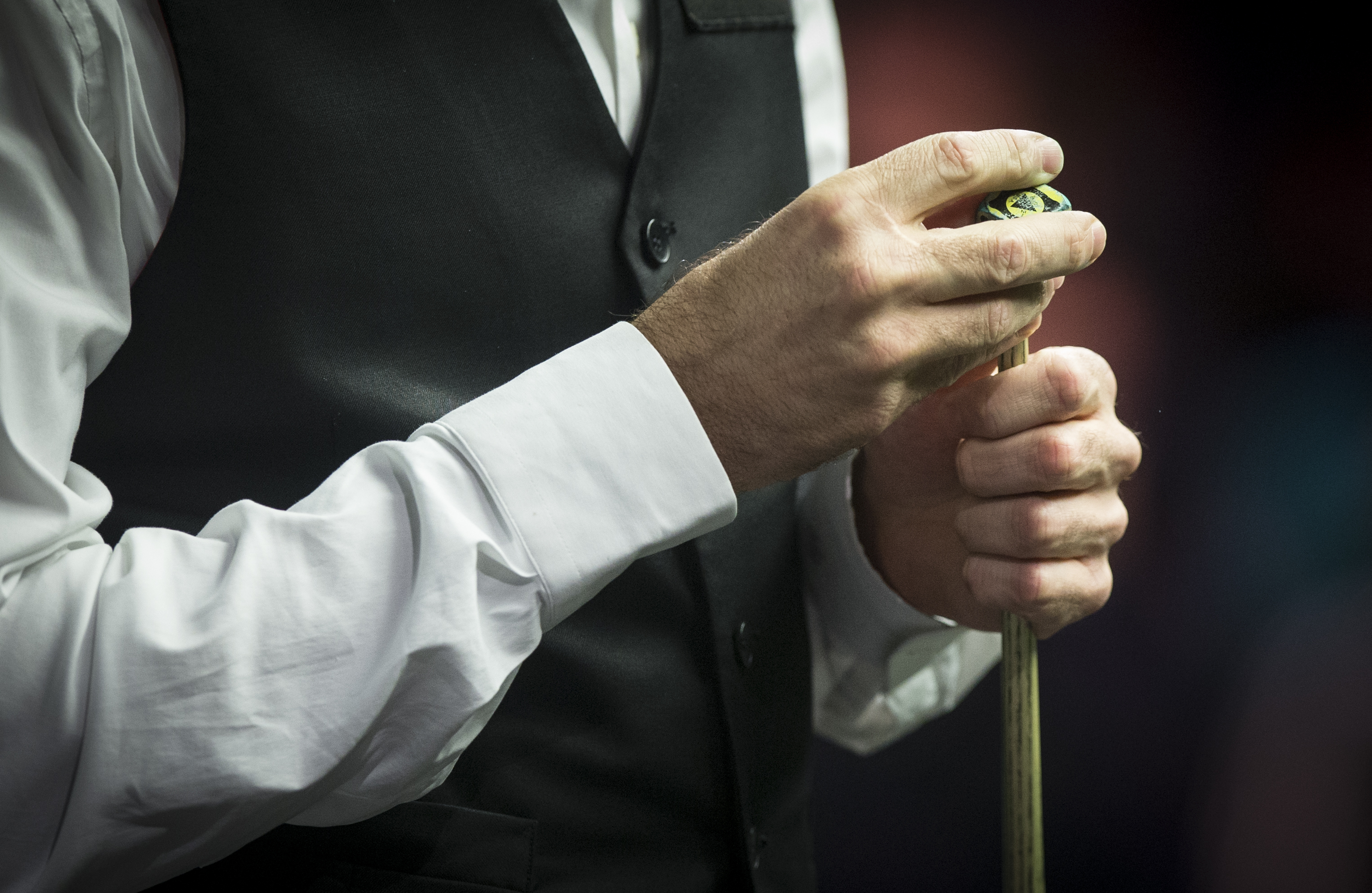 A snooker player chalks their cue