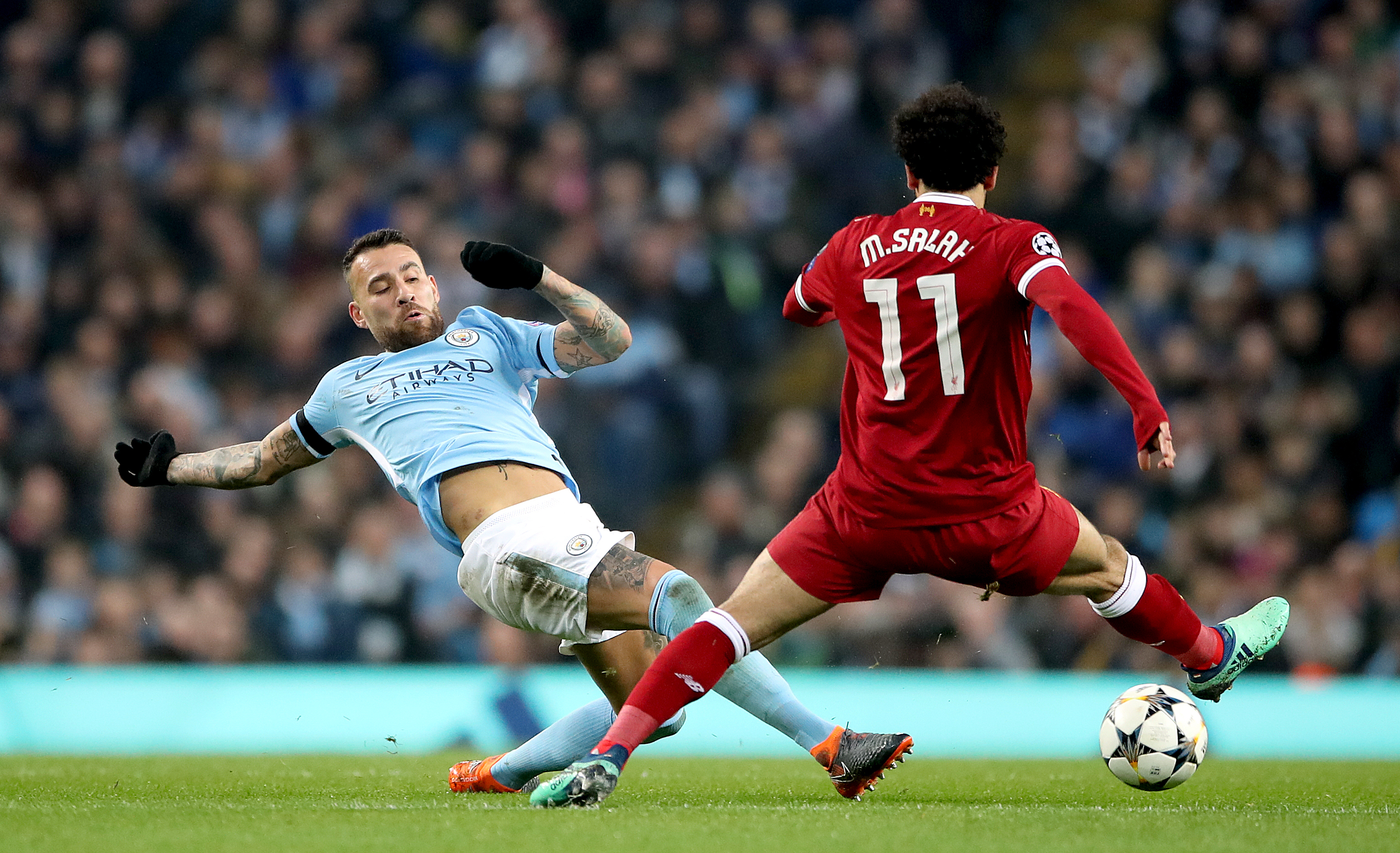 Manchester City's Nicolas Otamendi makes a tackle on Mohamed Salah