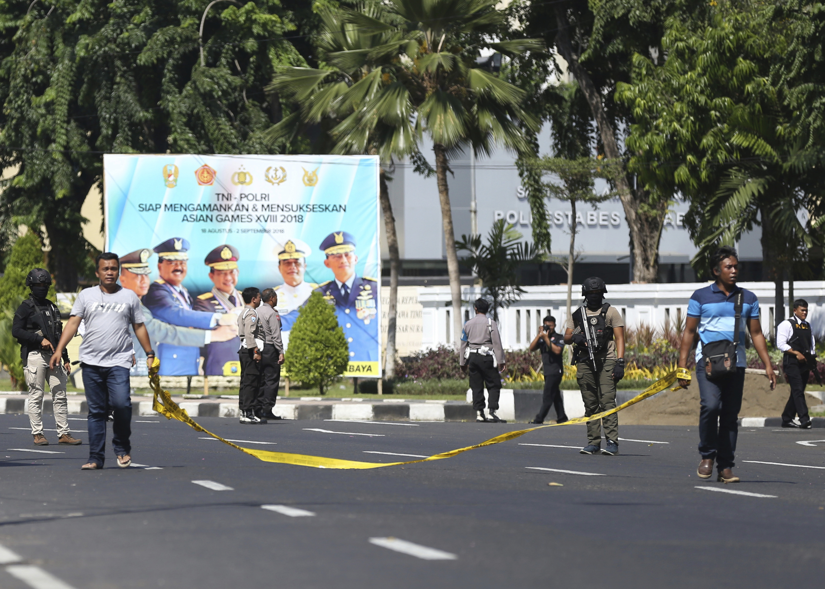 Officers set up a police line outside the local police headquarters following an attack in Surabaya (Achmad Ibrahim/AP)