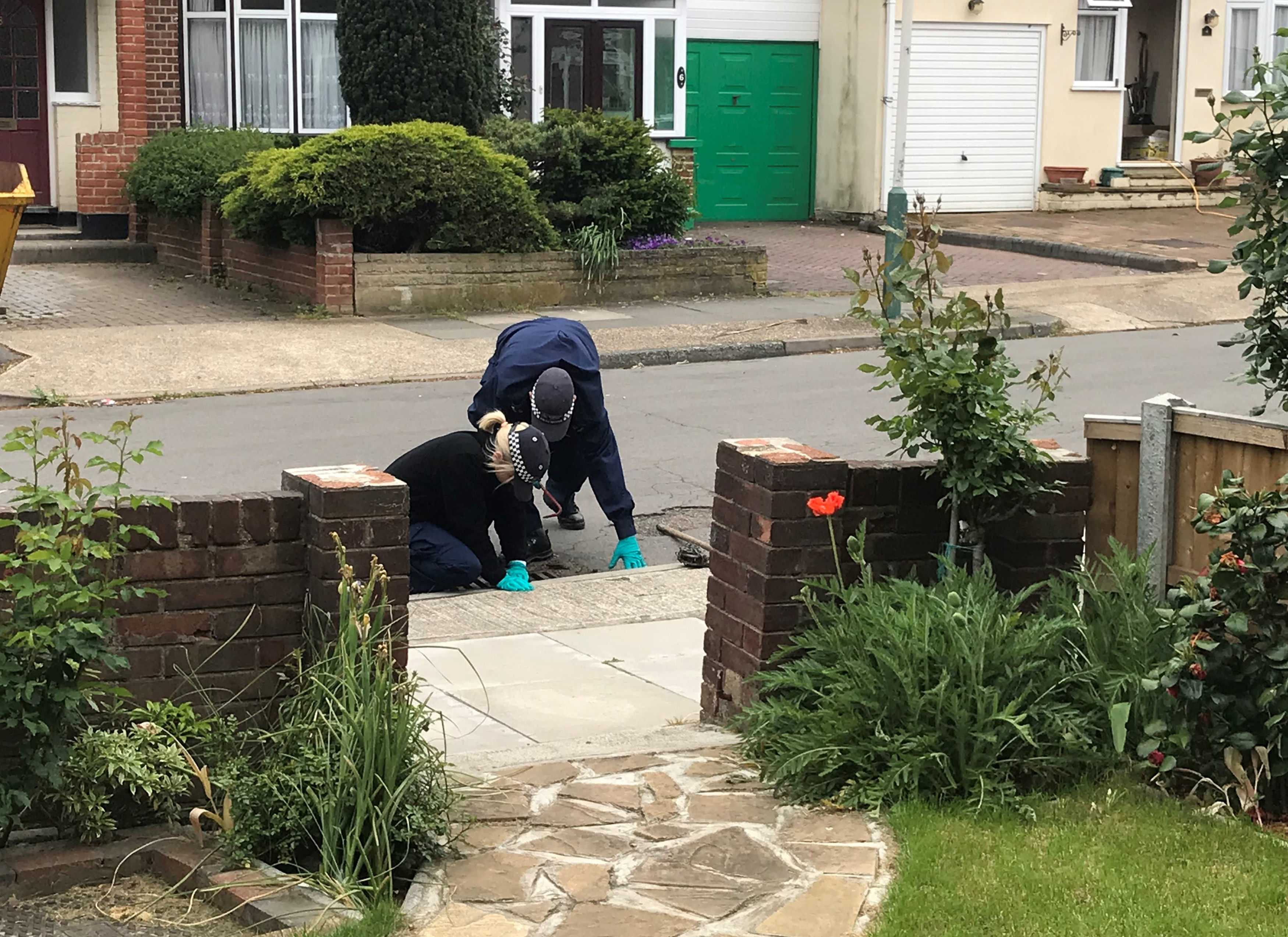 Police officers searching drains  in Ashmour Gardens, Romford (Thomas Hornall/PA)