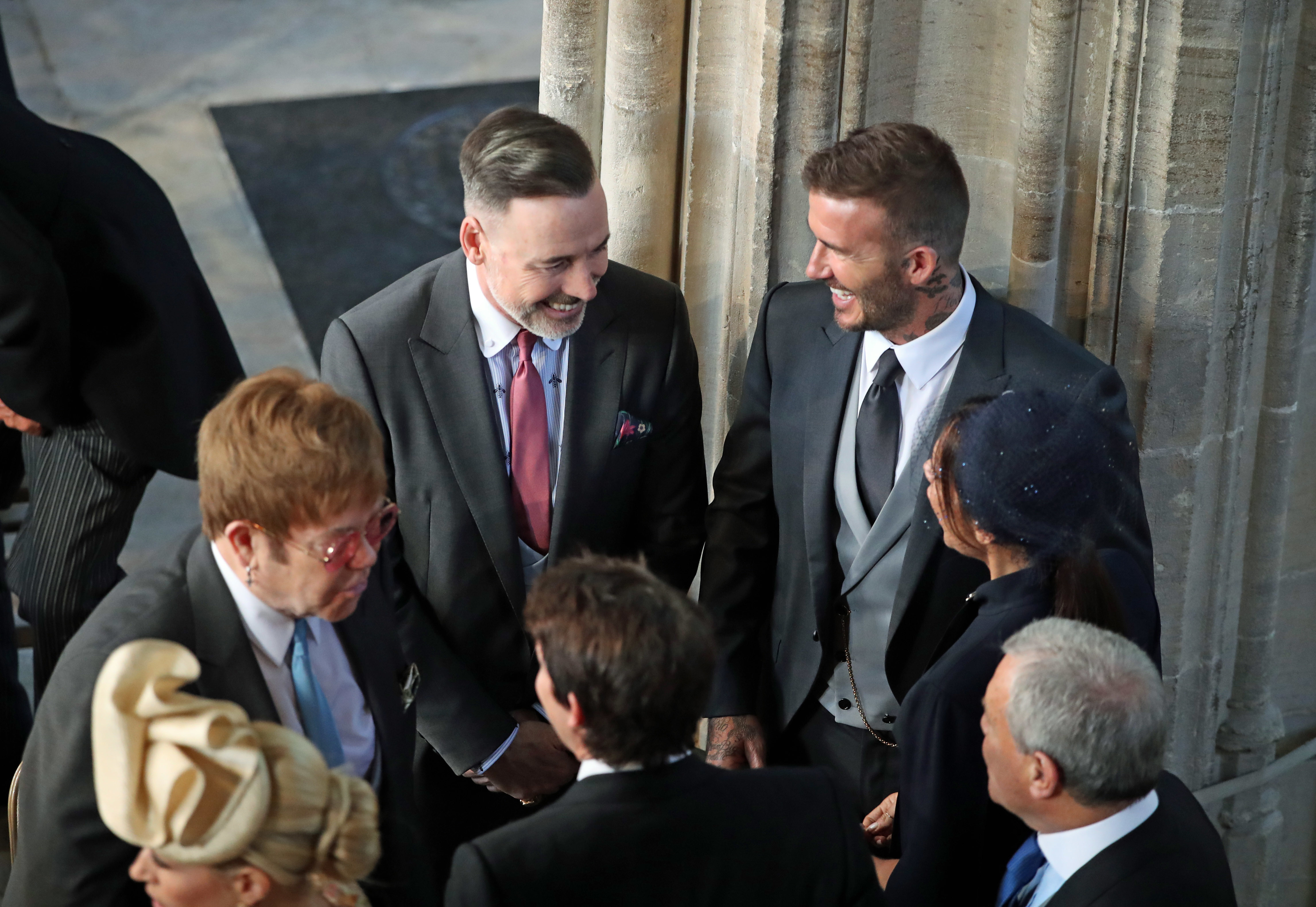 David and Victoria Beckham (both right) talk with Sir Elton John (left) and David Furnish as they arrive in St George's Chapel at Windsor Castle for the wedding of Prince Harry and Meghan Markle.