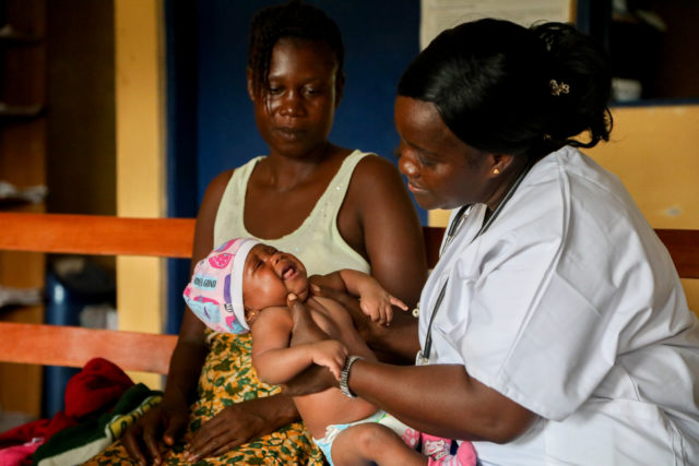 Midwife Alice checks over baby Alice at White Plains Clinic, Liberia (Save the Children)