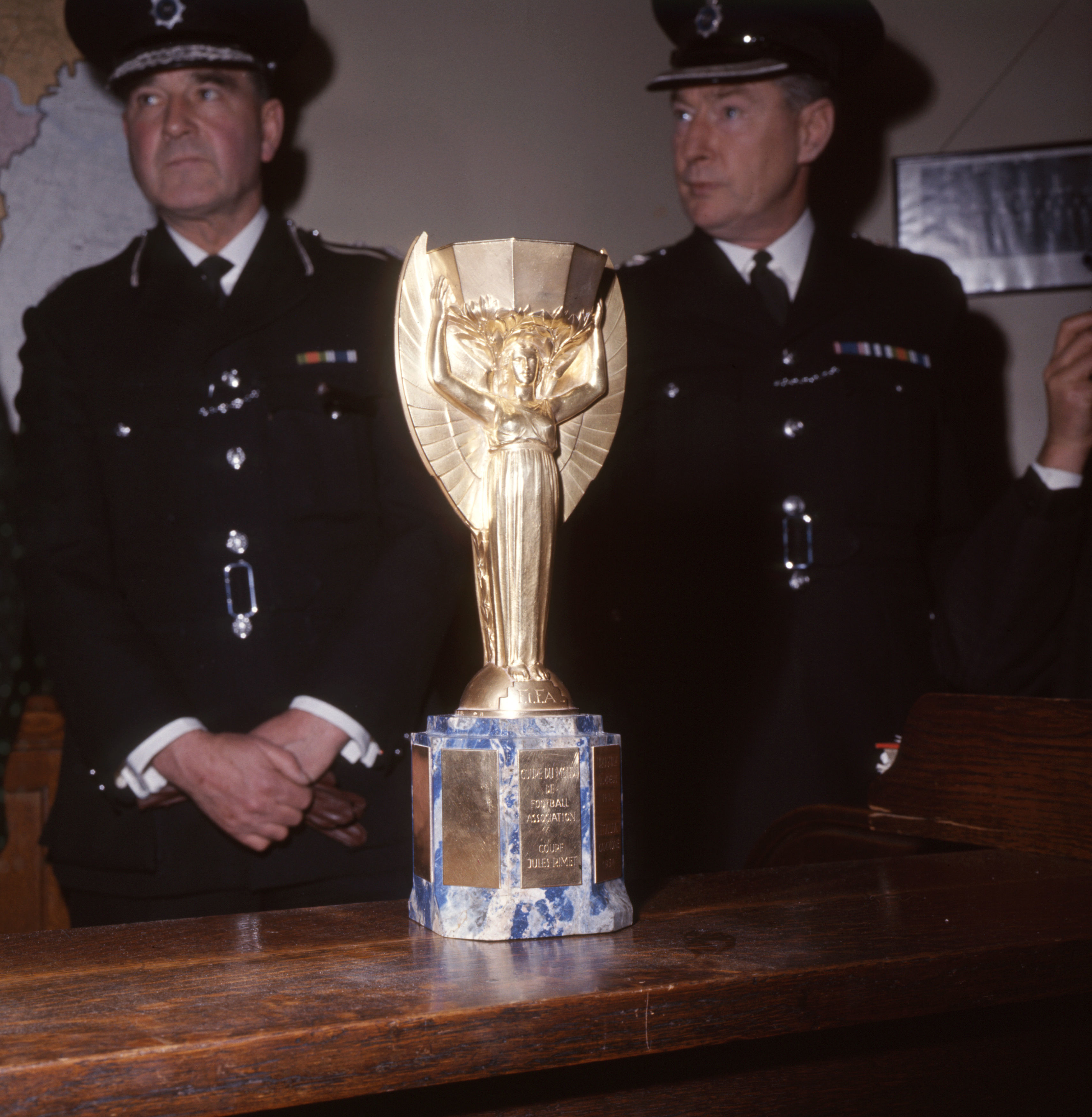 Police officers with the recovered World Cup trophy (PA)