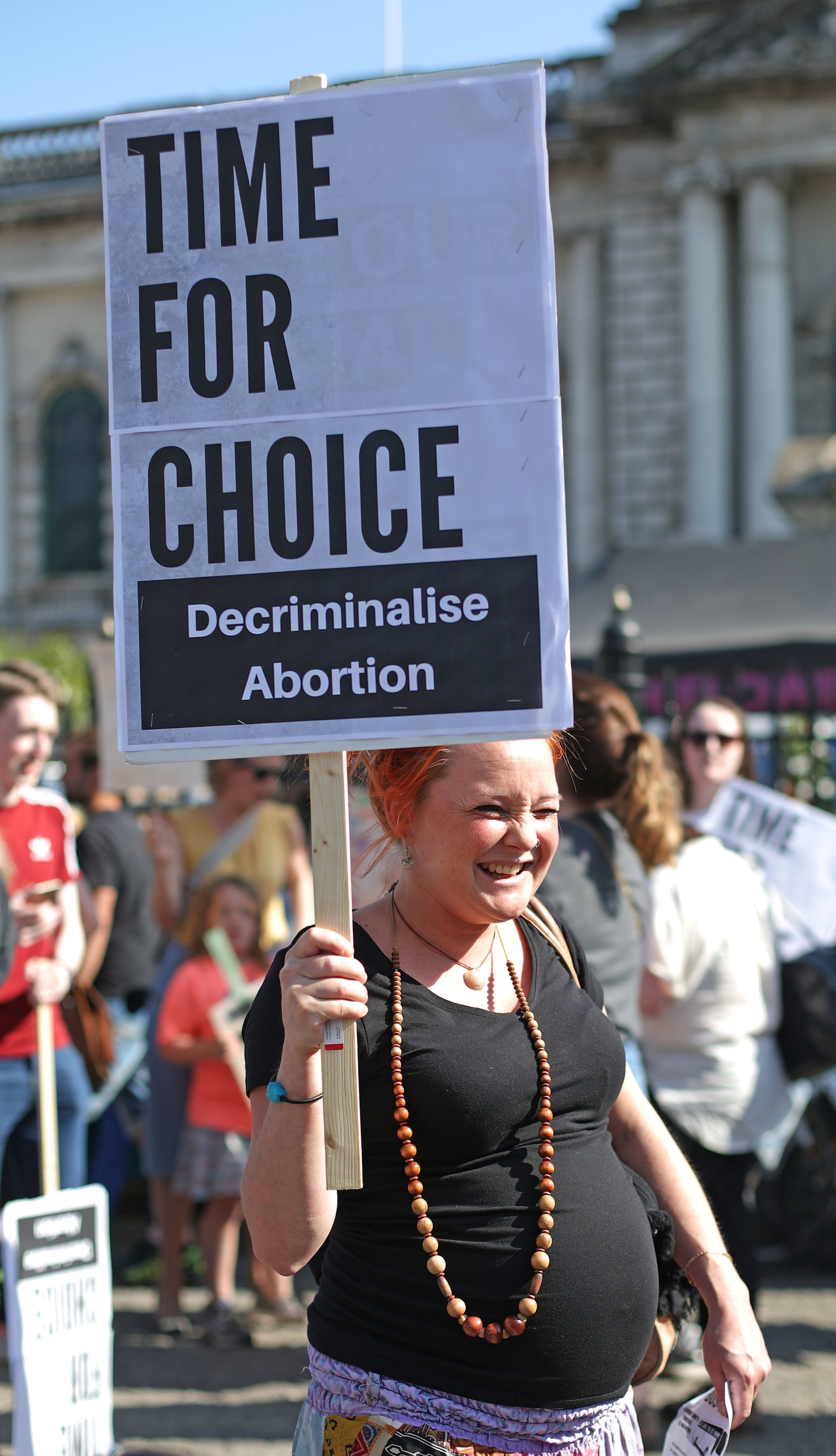 A pregnant woman holds a sign outside Belfast City Hall (Niall Carson/PA)