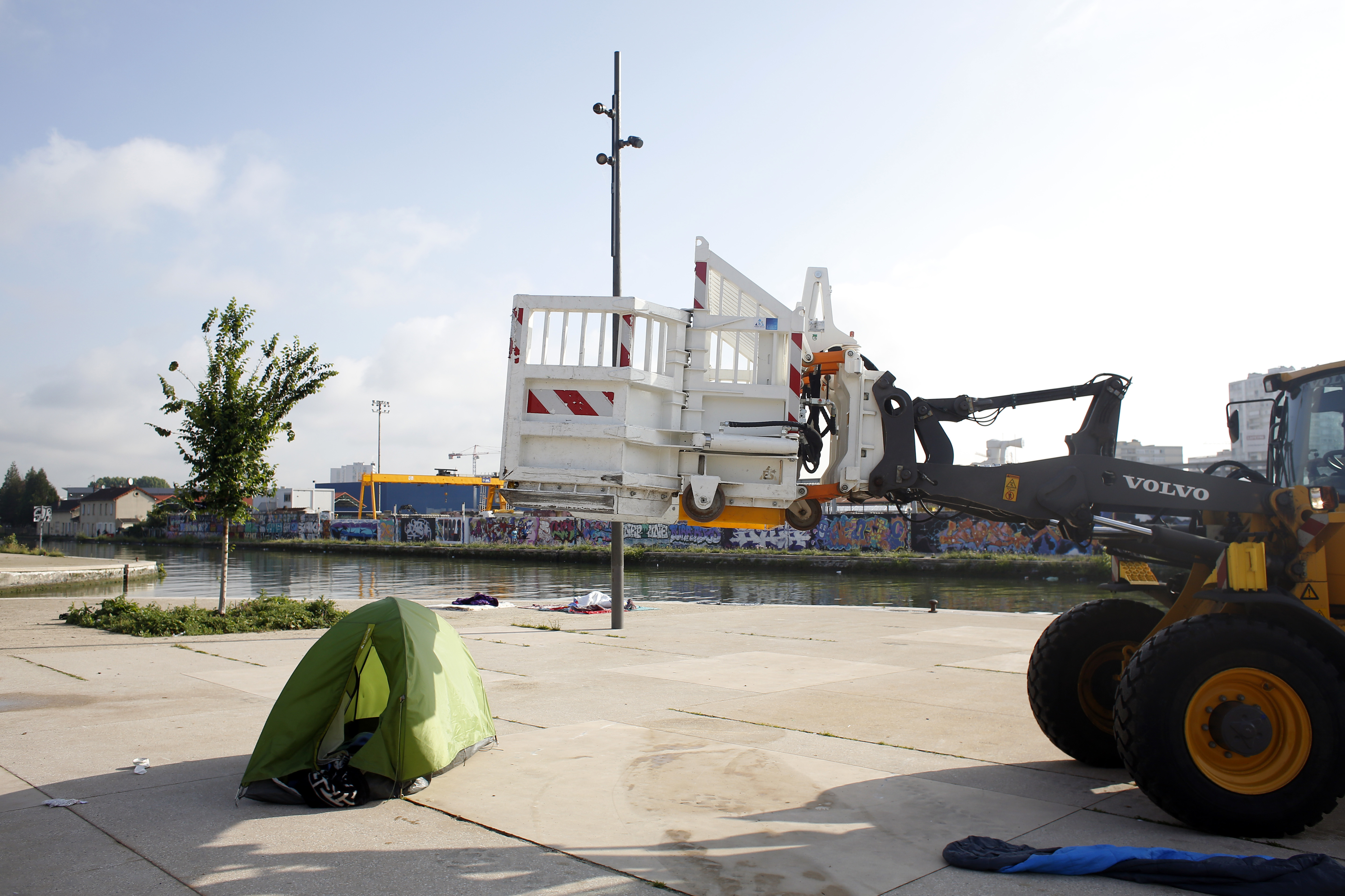 A bulldozer clears a migrant makeshift camp in Paris 