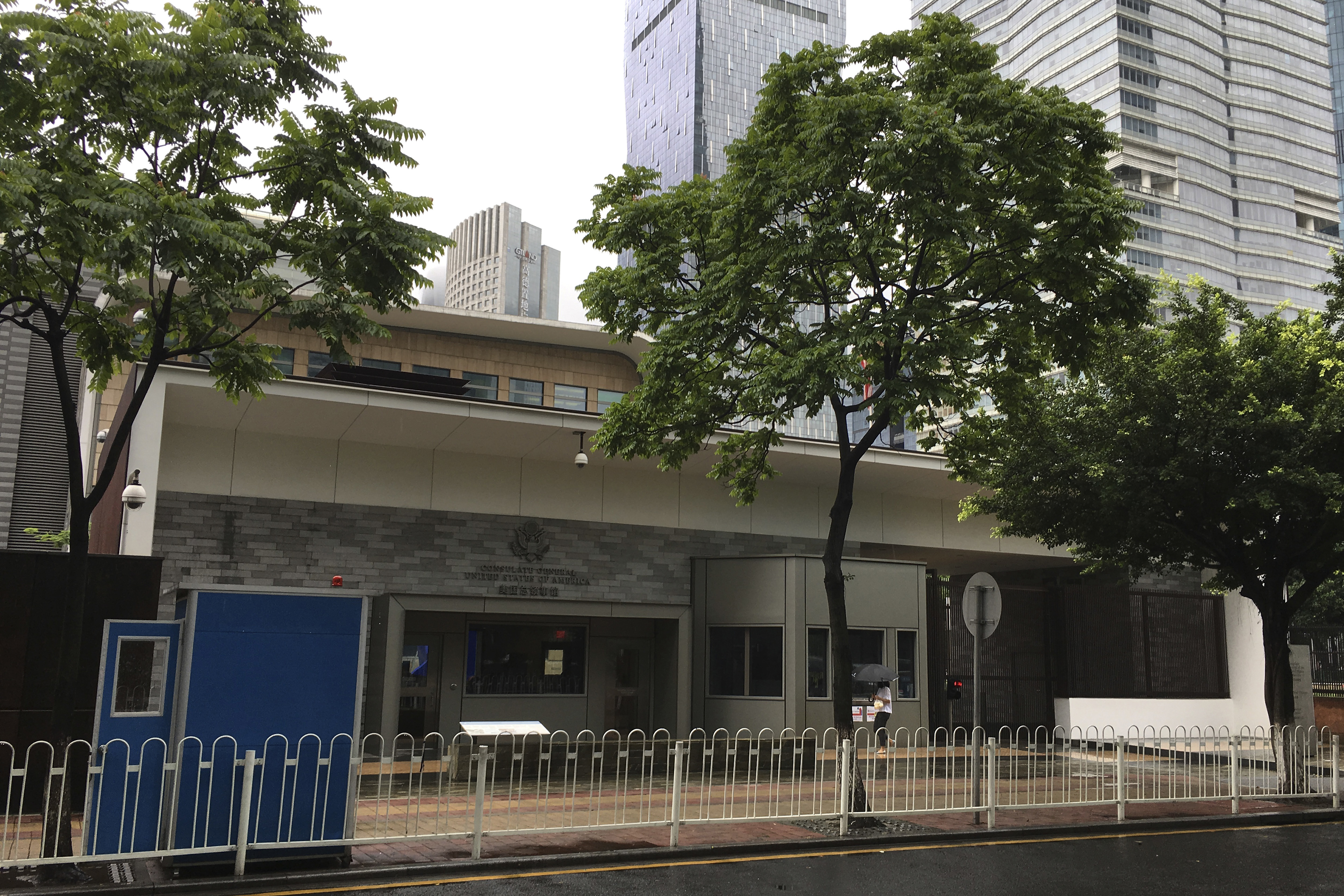 A woman walks past the US consulate building in Guangzhou in southern China