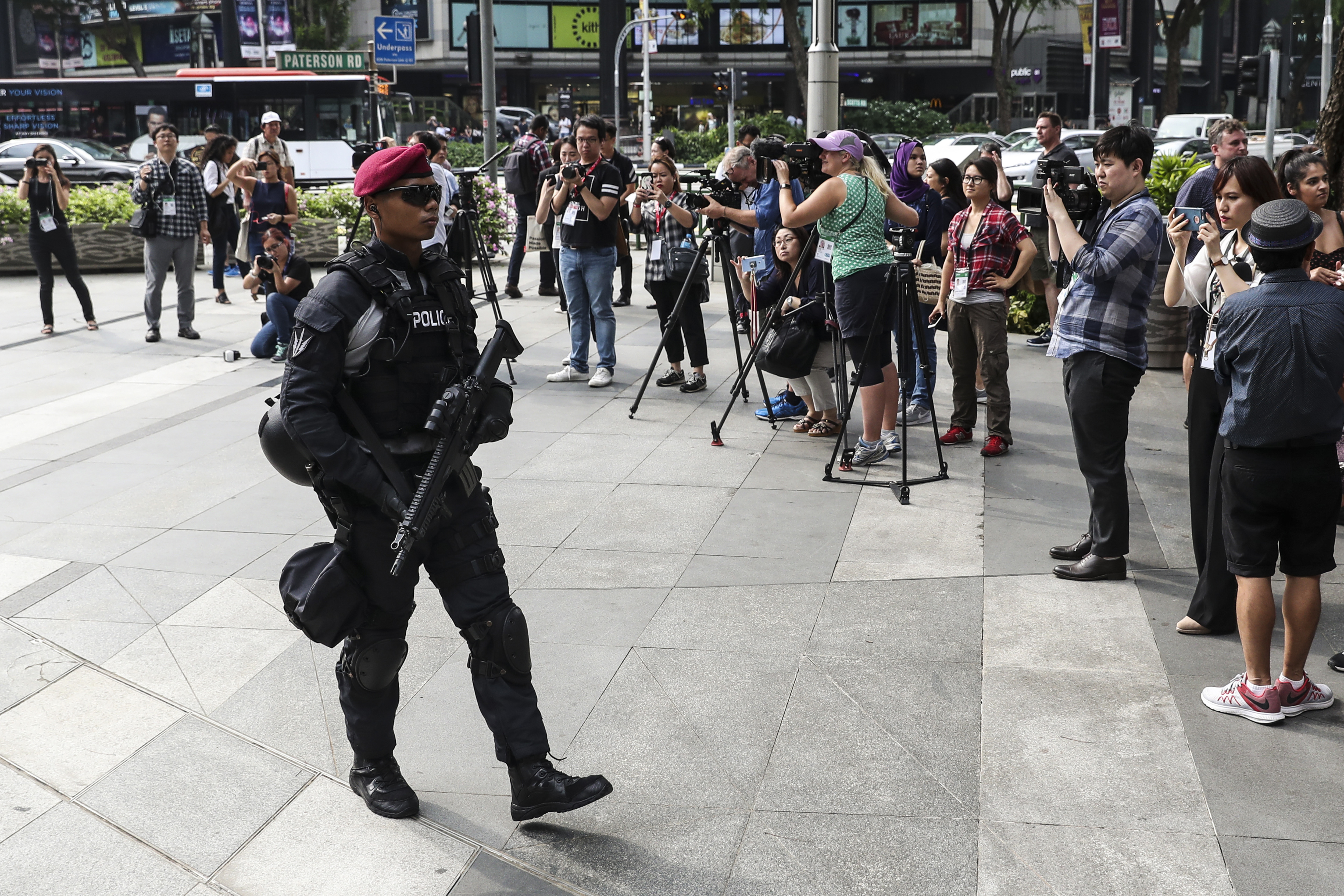 Members of the media take photos and video of police patrolling Orchard Road in Singapore