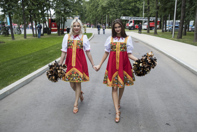 Two women dressed in Russian traditional costumes walk near the Luzhniki Stadium