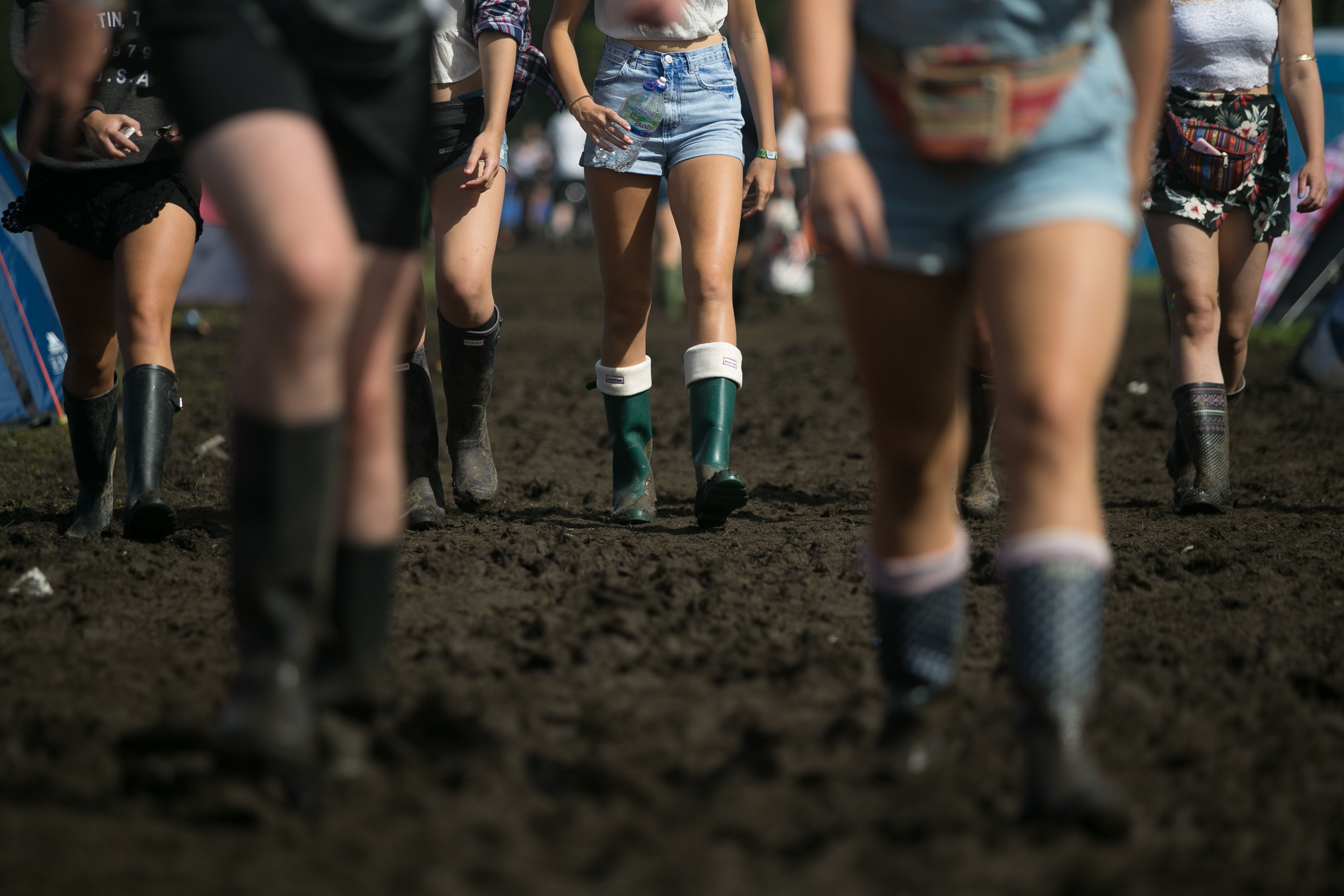 Festival goers walking in the mud on the first day of the Reading Festival in Berkshire.