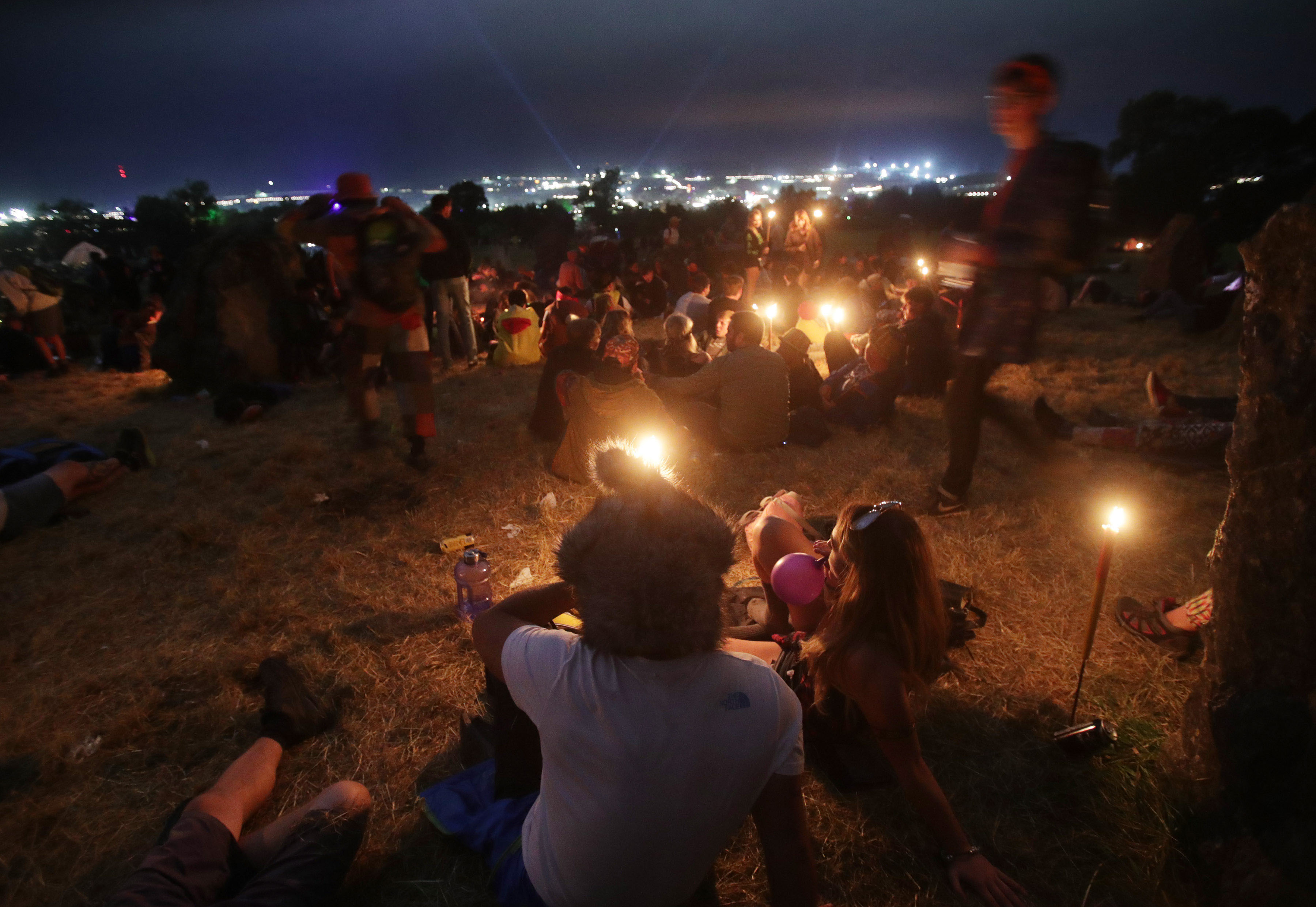 Festival goers at the Stone Circle in the early hours of the morning, at the Glastonbury Festival at Worthy Farm in Pilton, Somerset.