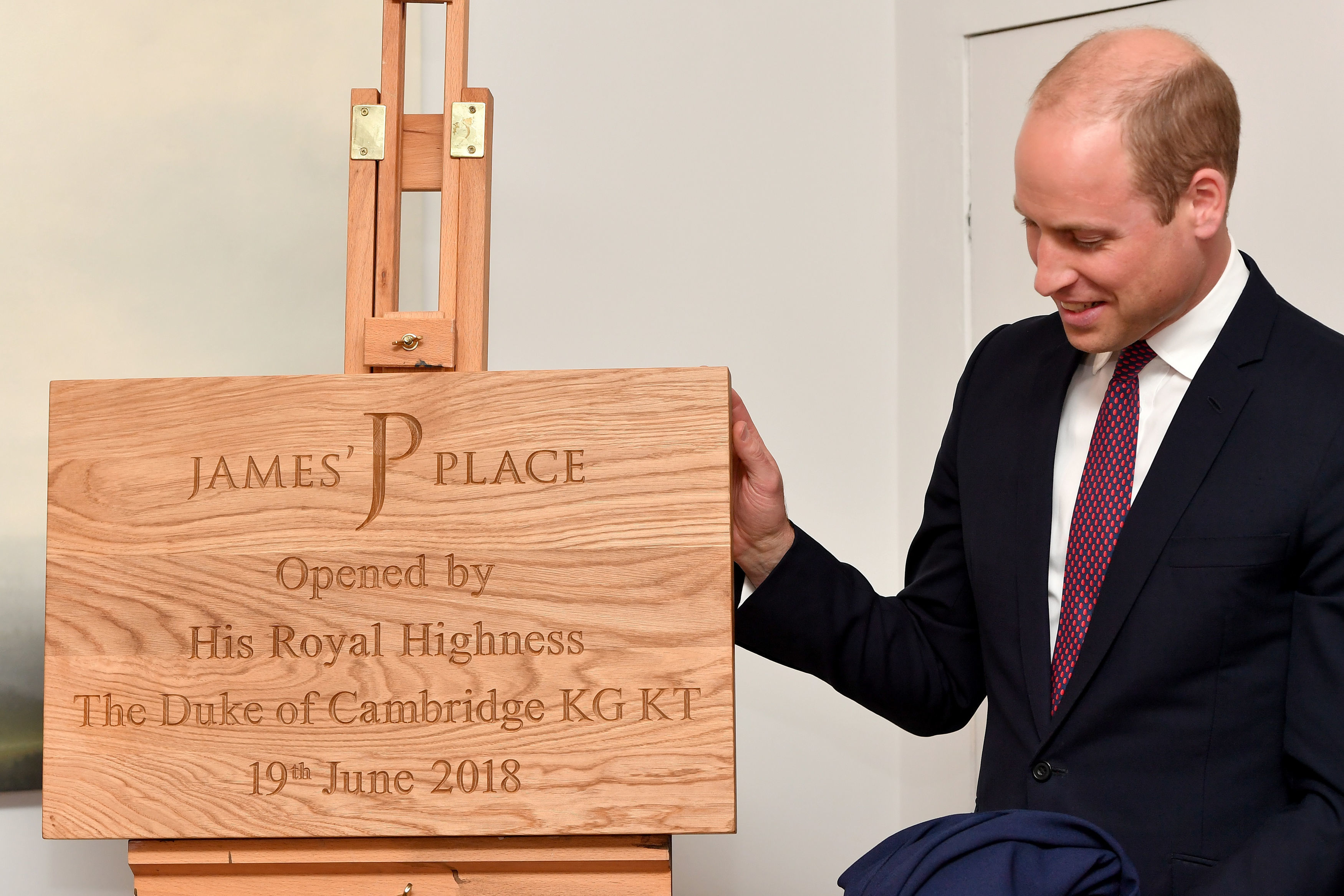 William unveils a plaque during a visit to James' Place in Liverpool 