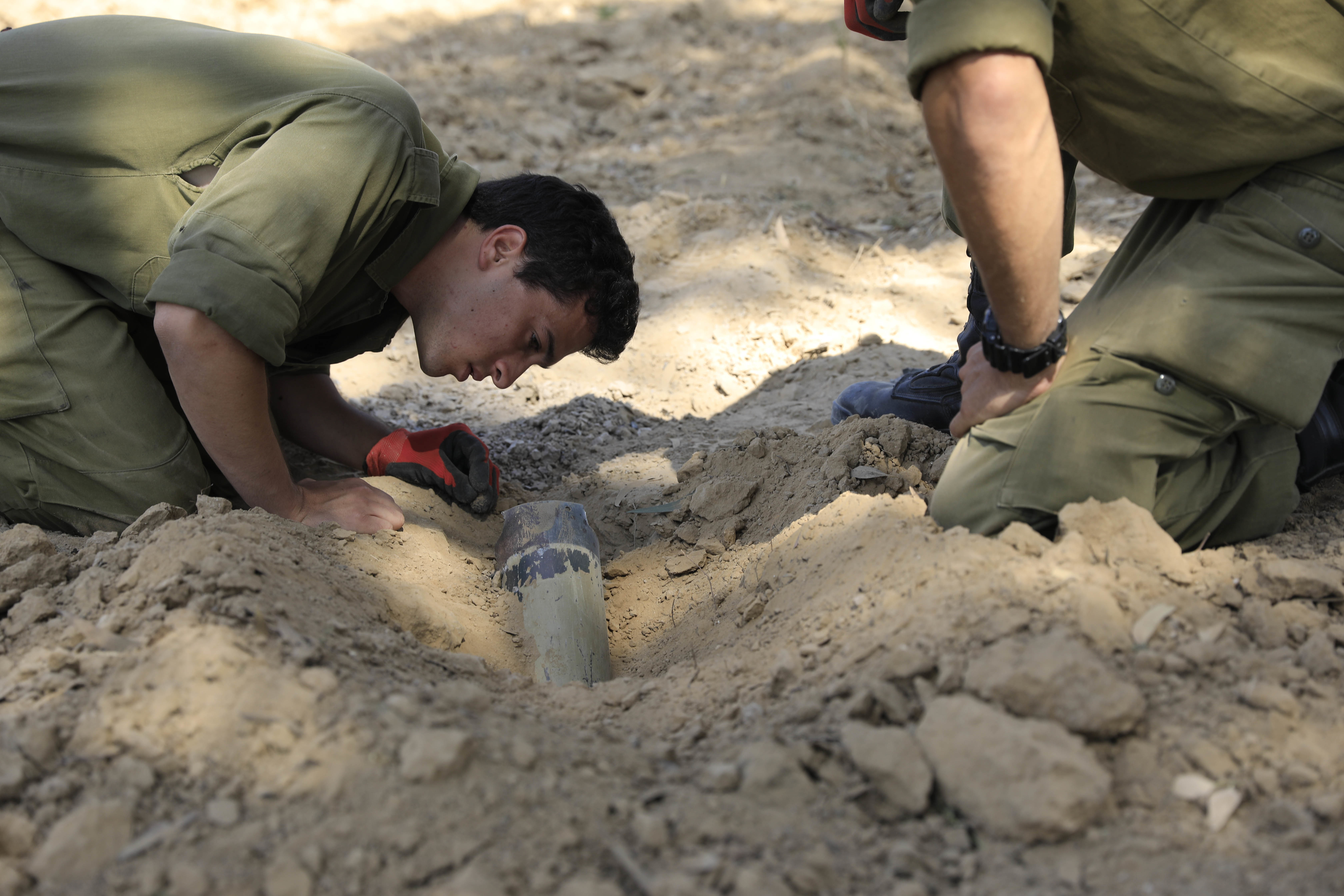 Israeli soldiers inspect a missile launched from the Gaza Strip